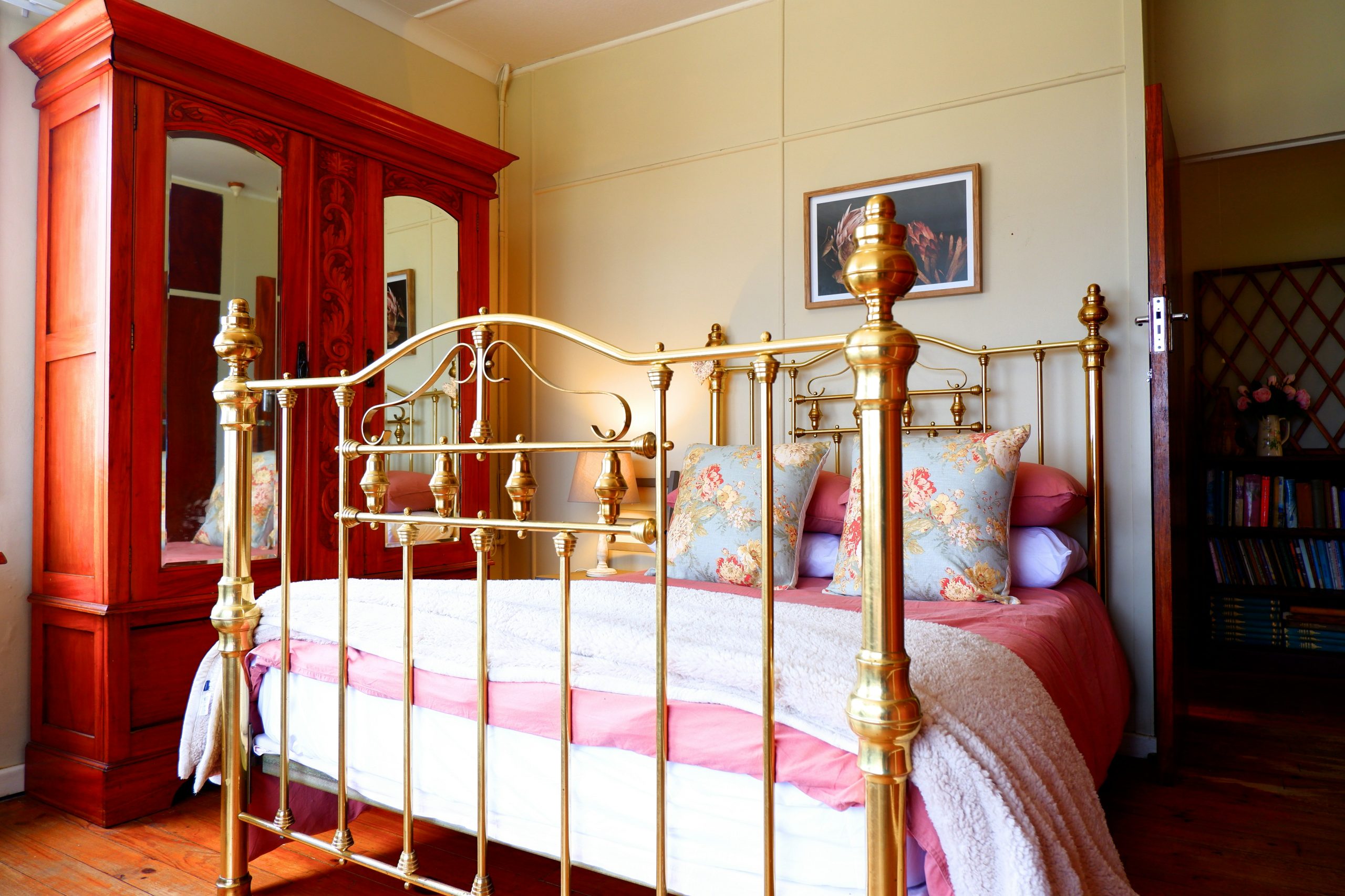 a bedroom with a gold bed and a red cabinet