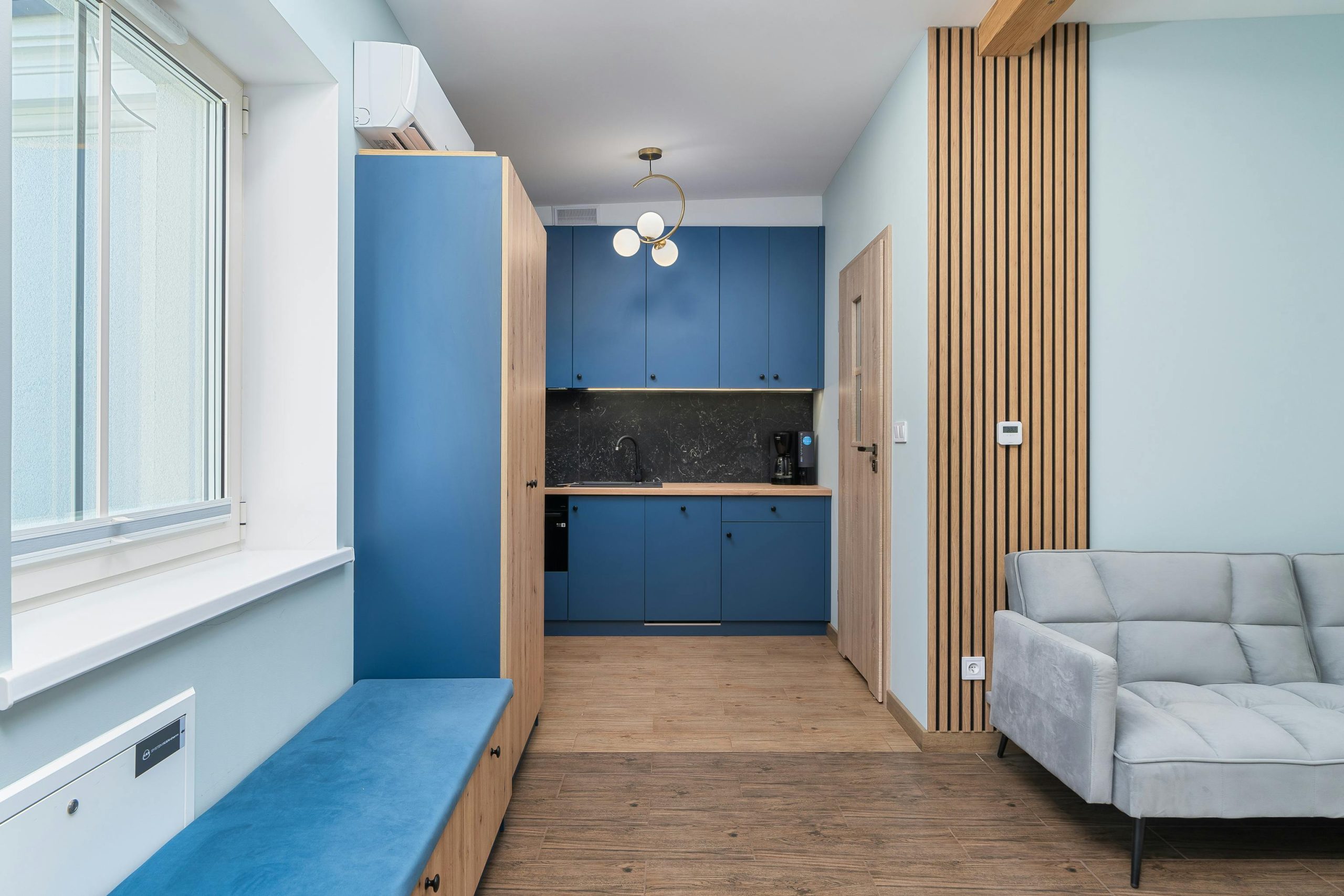 A bright, modern kitchen with blue cabinets and wooden accents, perfect for small spaces.