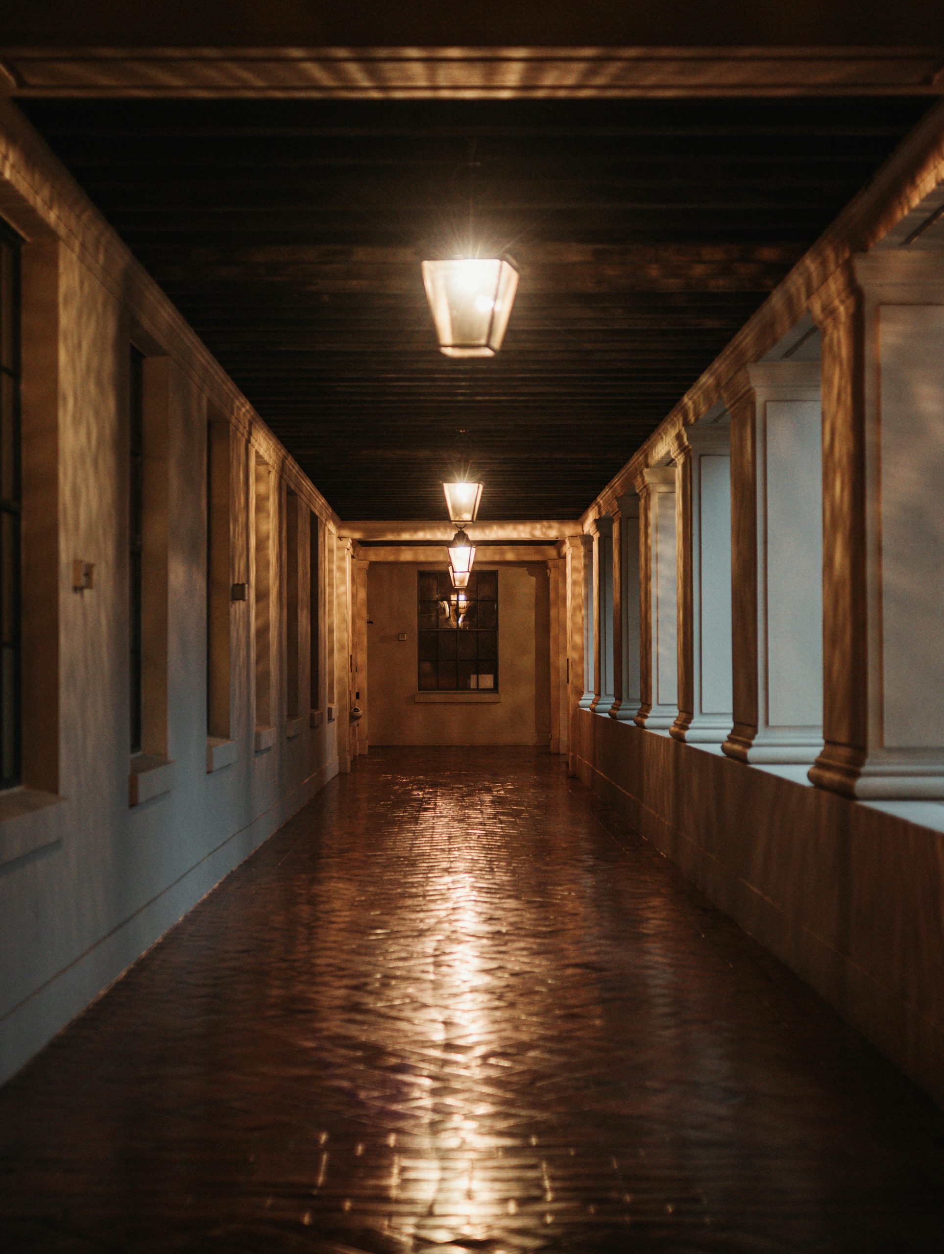 A luxurious indoor corridor with elegant lighting and paved floors, exuding warmth and sophistication.