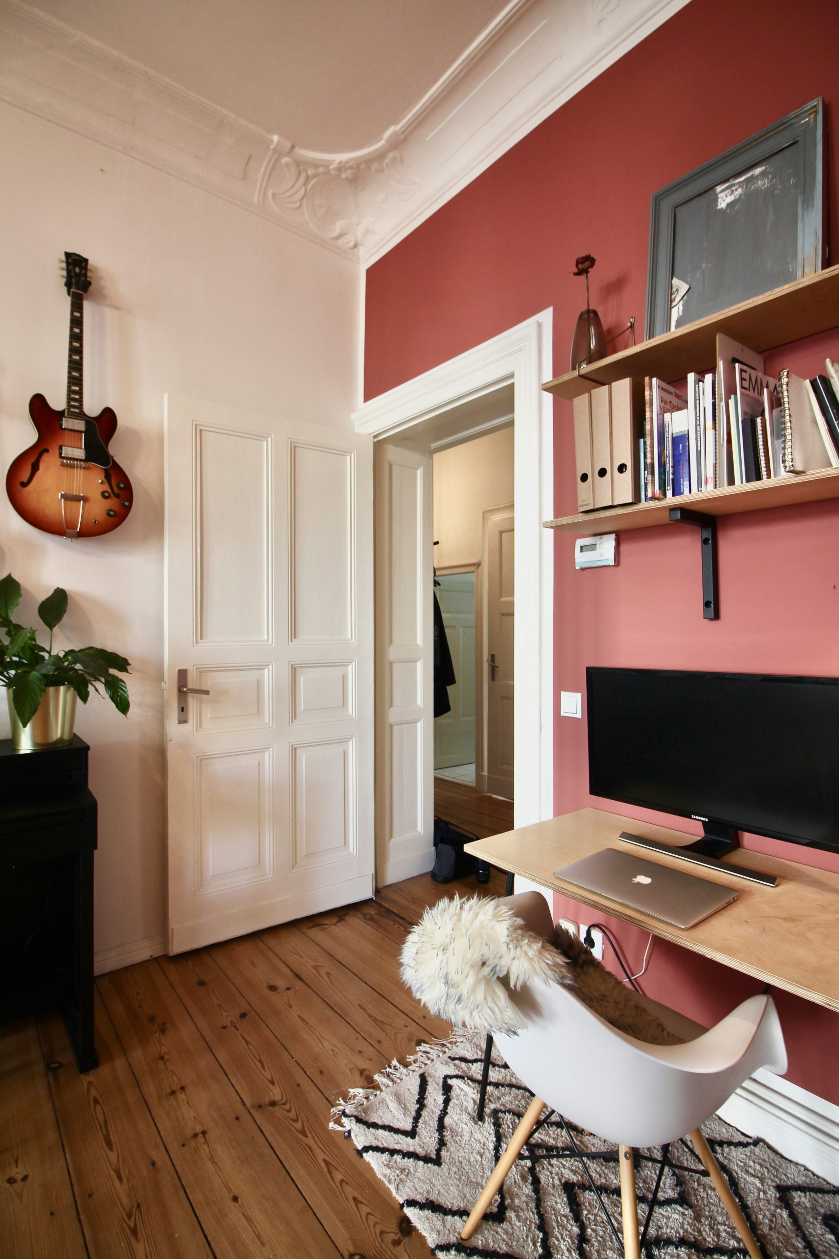 A musician's home in Berlin, Germany. Home office with pink walls and guitars, to work from home comfortably. Available for rent as a film location on beazy.co