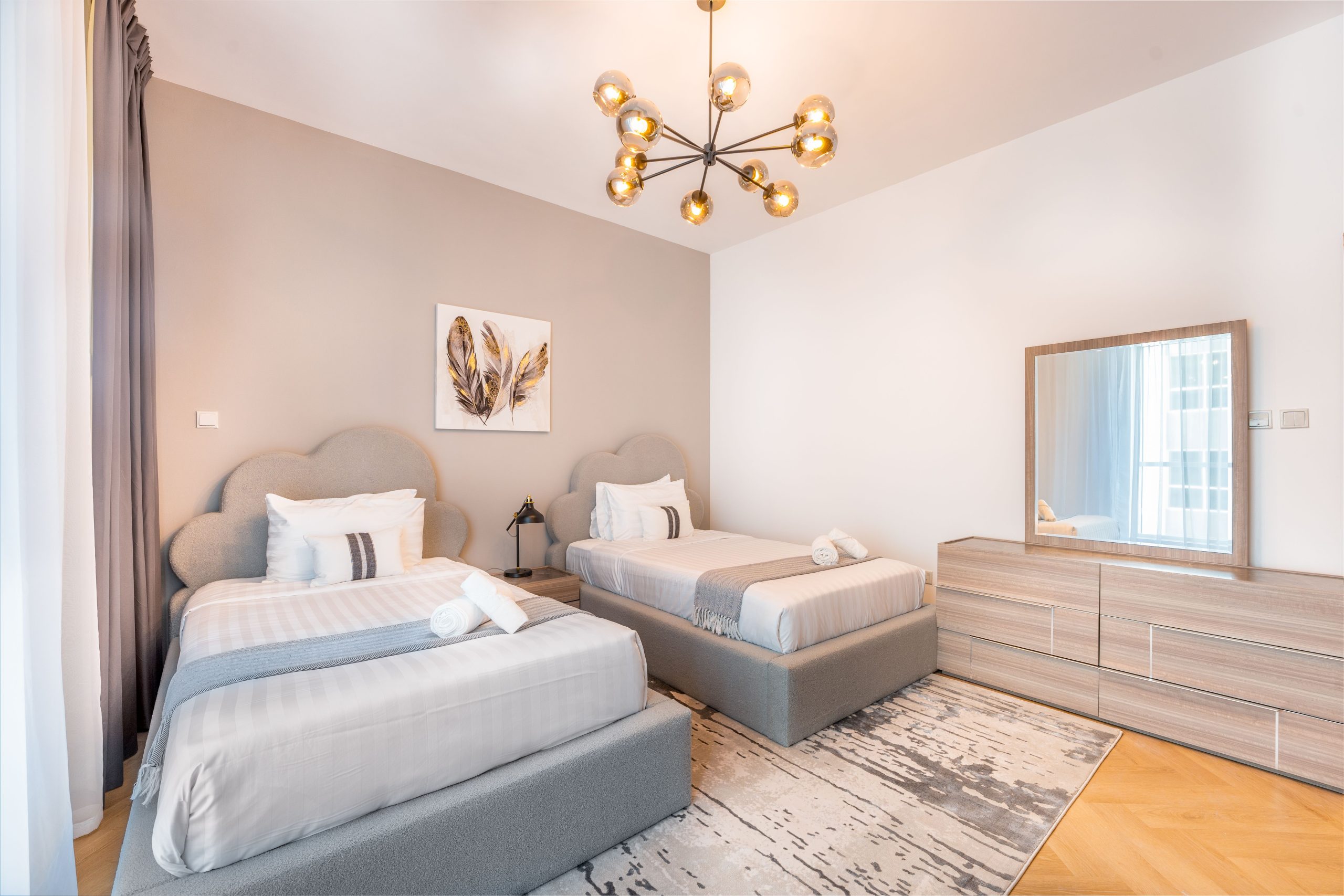 A stylish modern twin bedroom with elegant decor and warm lighting ambiance.