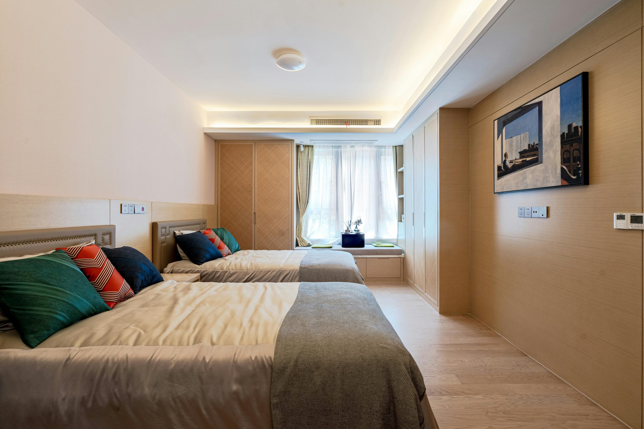 A well-organized minimalist bedroom with twin beds and elegant decor.
