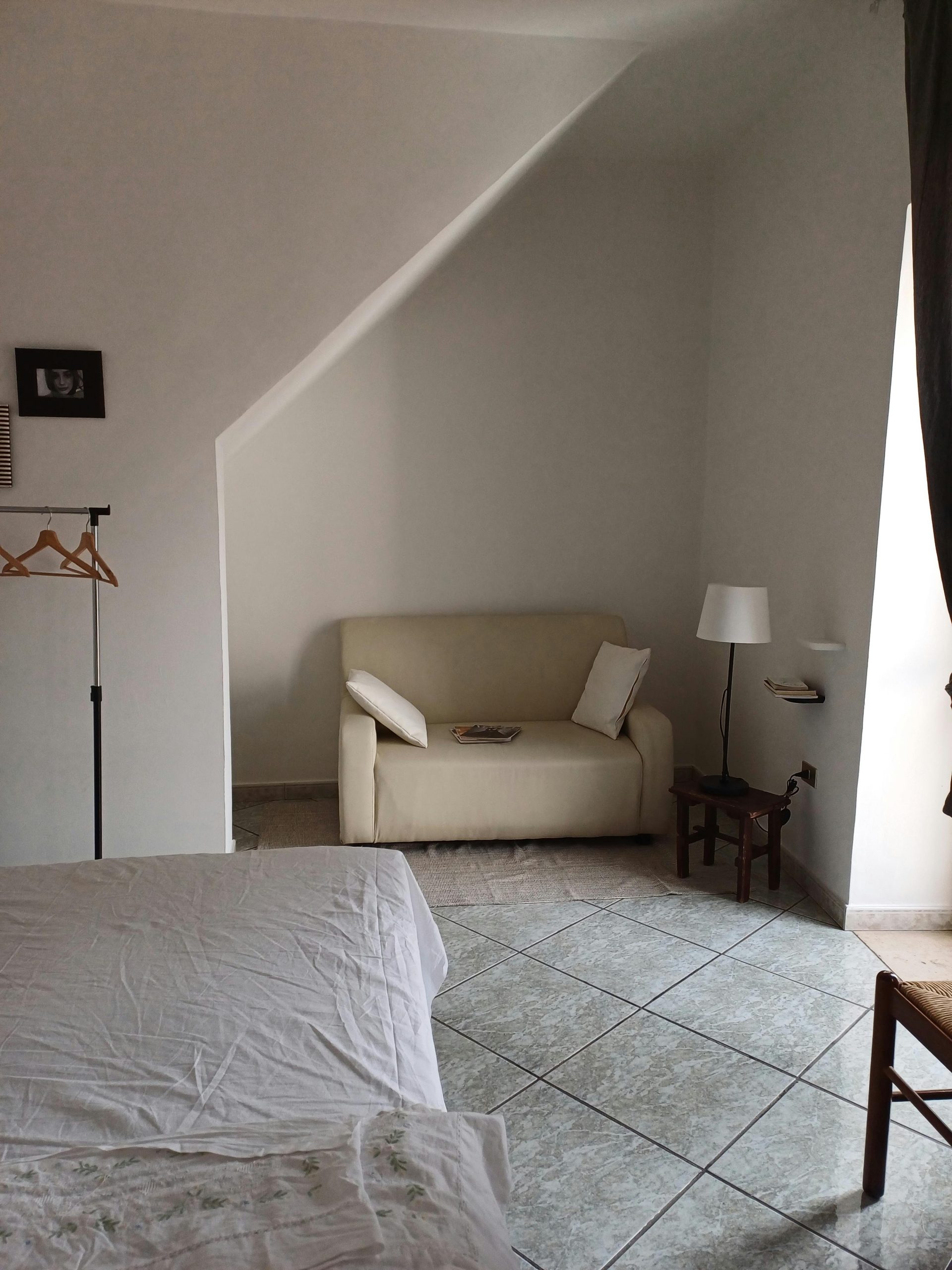Bright and minimalist bedroom featuring a cozy sofa, bed, and modern decor.