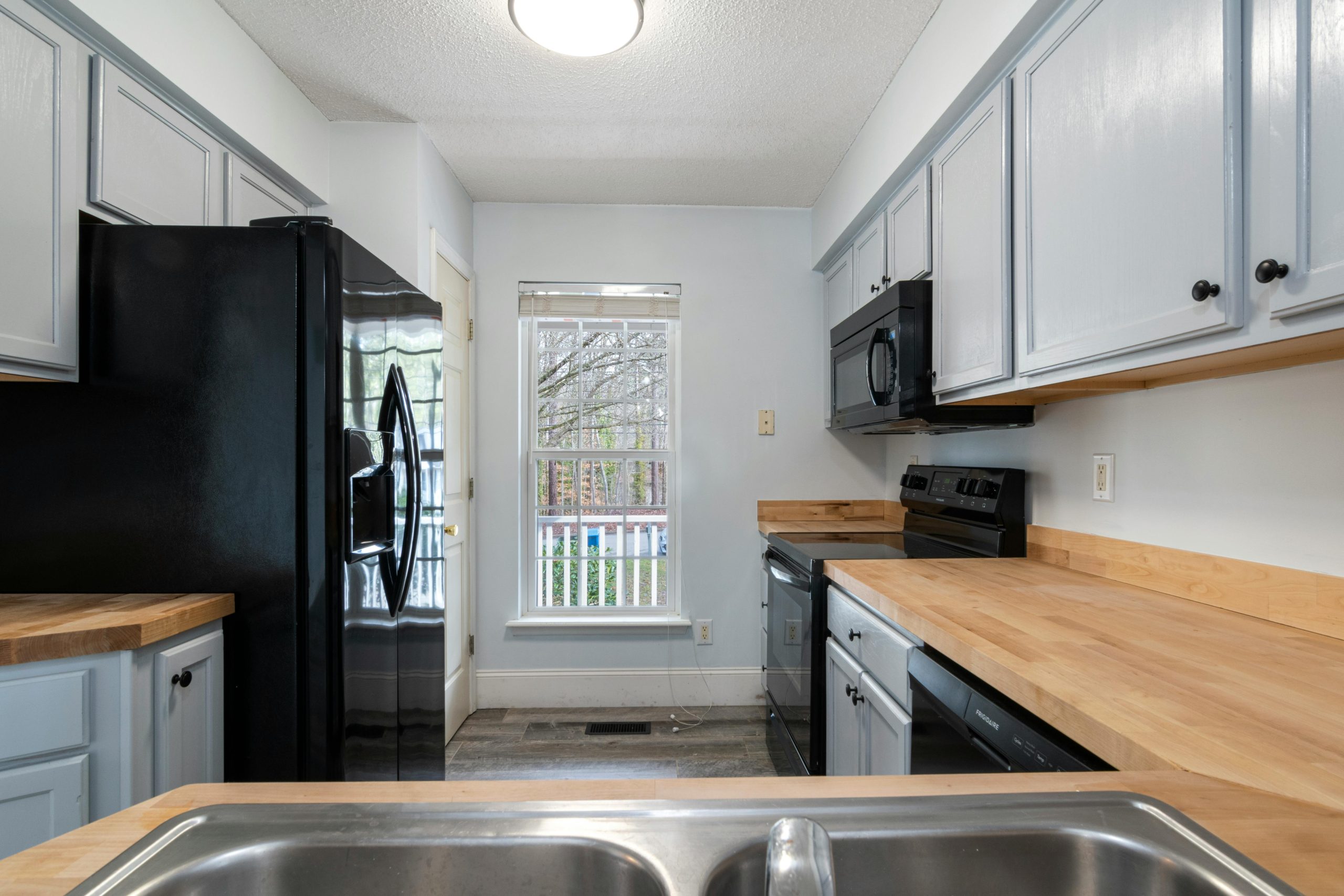 Bright and spacious kitchen featuring modern design with wooden countertops and stainless steel appliances.