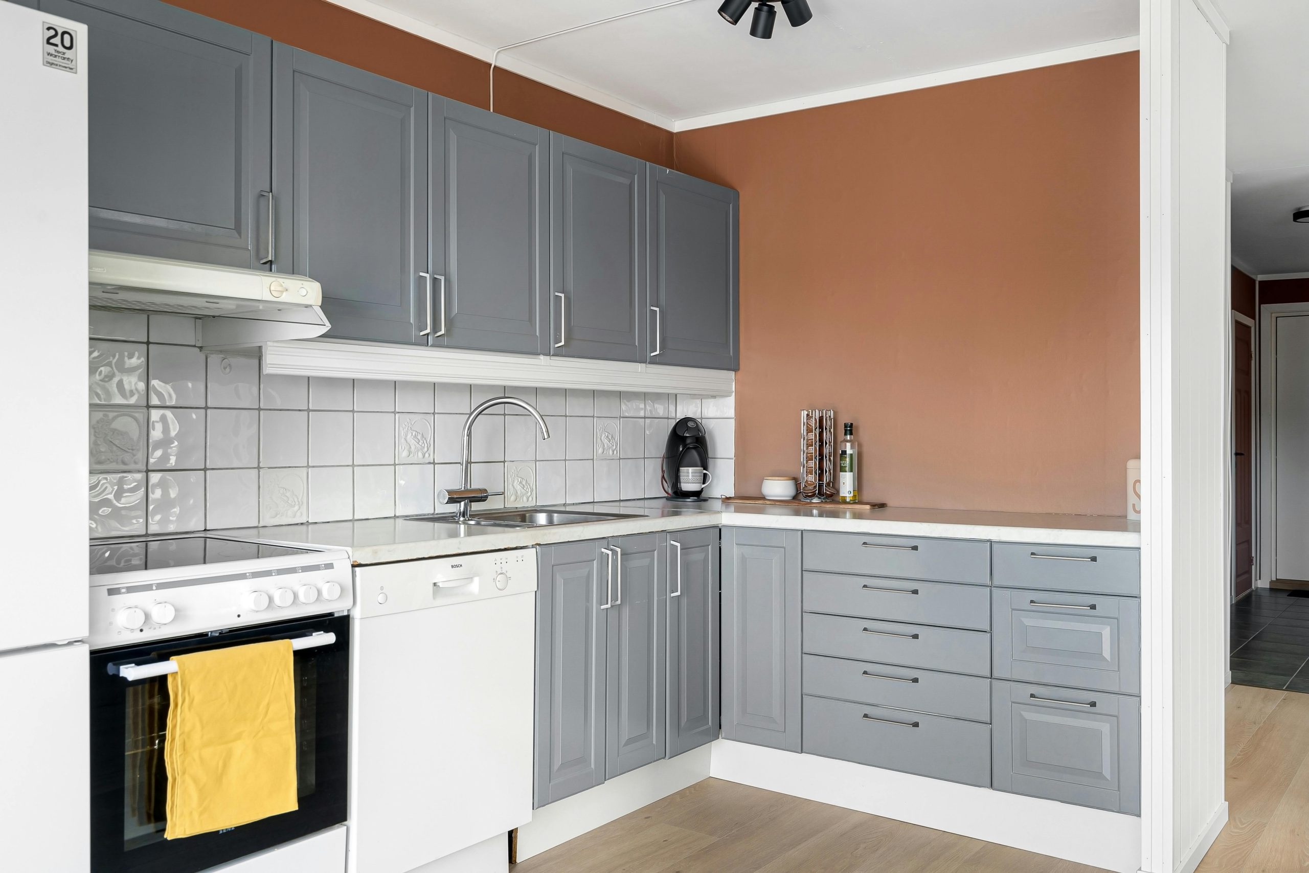Chic minimalist kitchen interior featuring gray cabinets and modern appliances.