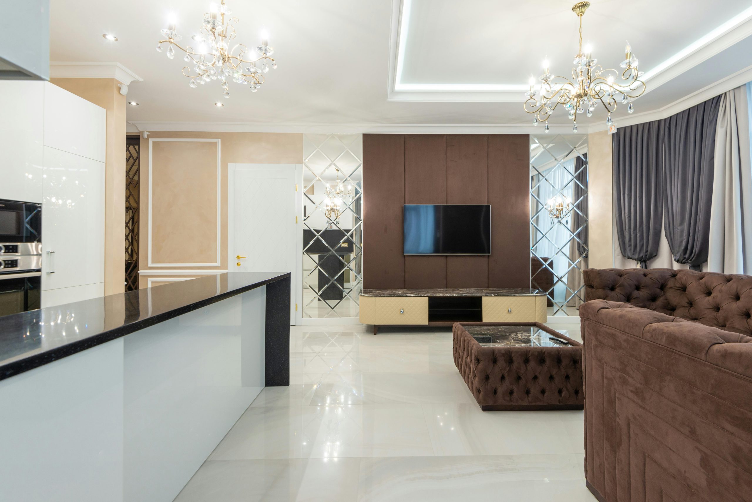 Chic modern living room with luxury decor, chandeliers, and a stylish couch.