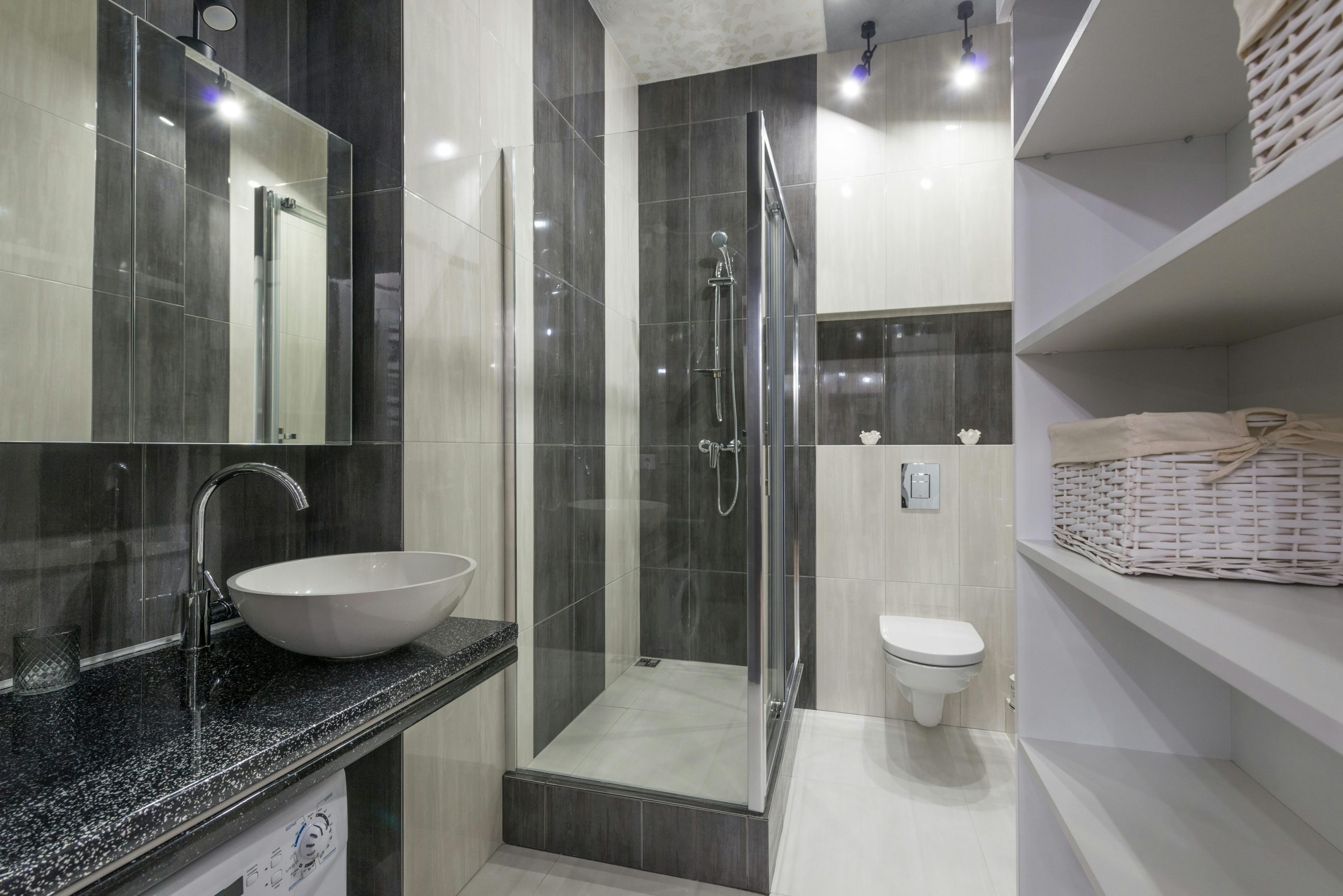 Contemporary bathroom design featuring glass shower, stylish sink, and storage shelving.