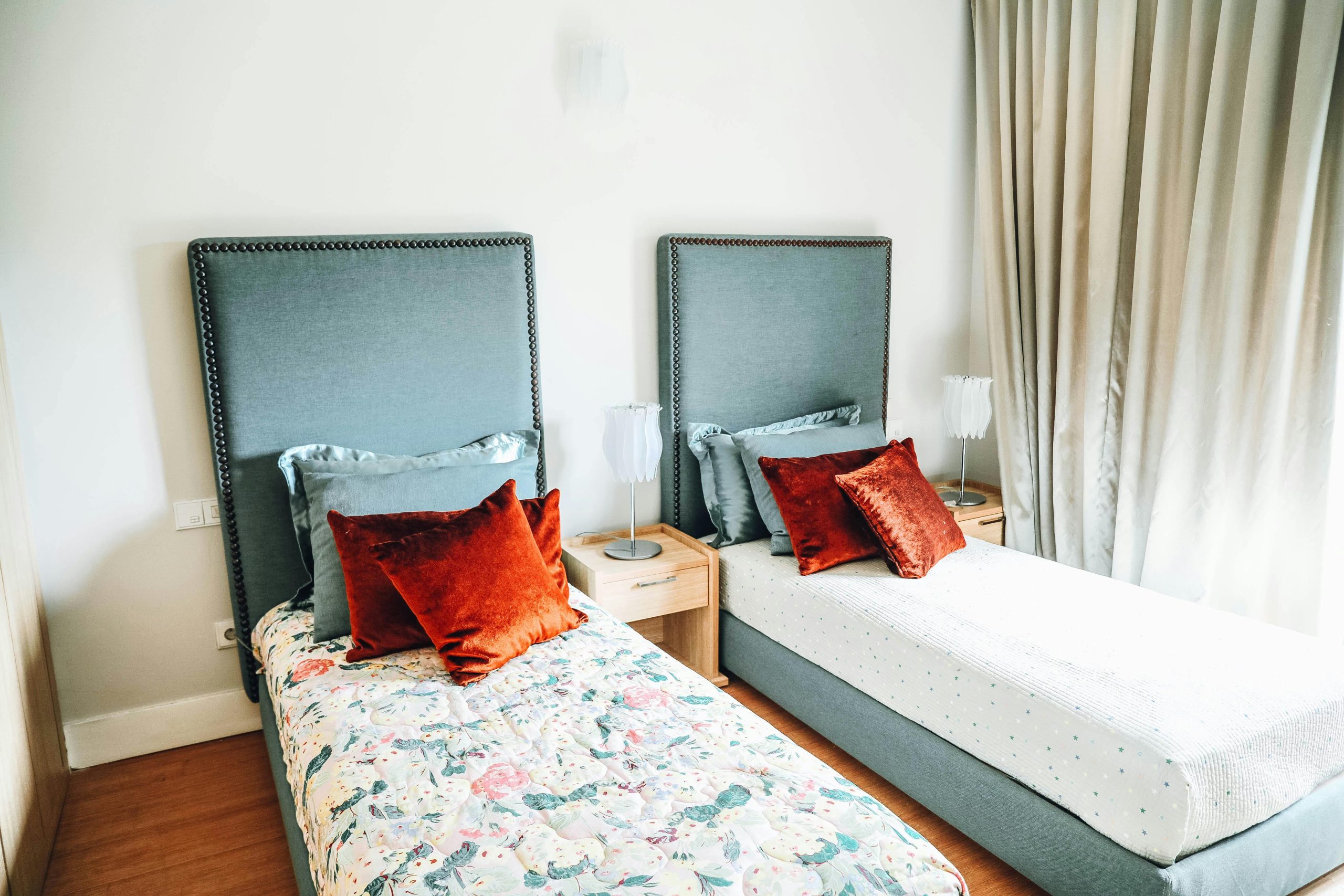 Contemporary twin bedroom showcasing stylish decor and plush cushions for a cozy ambiance.