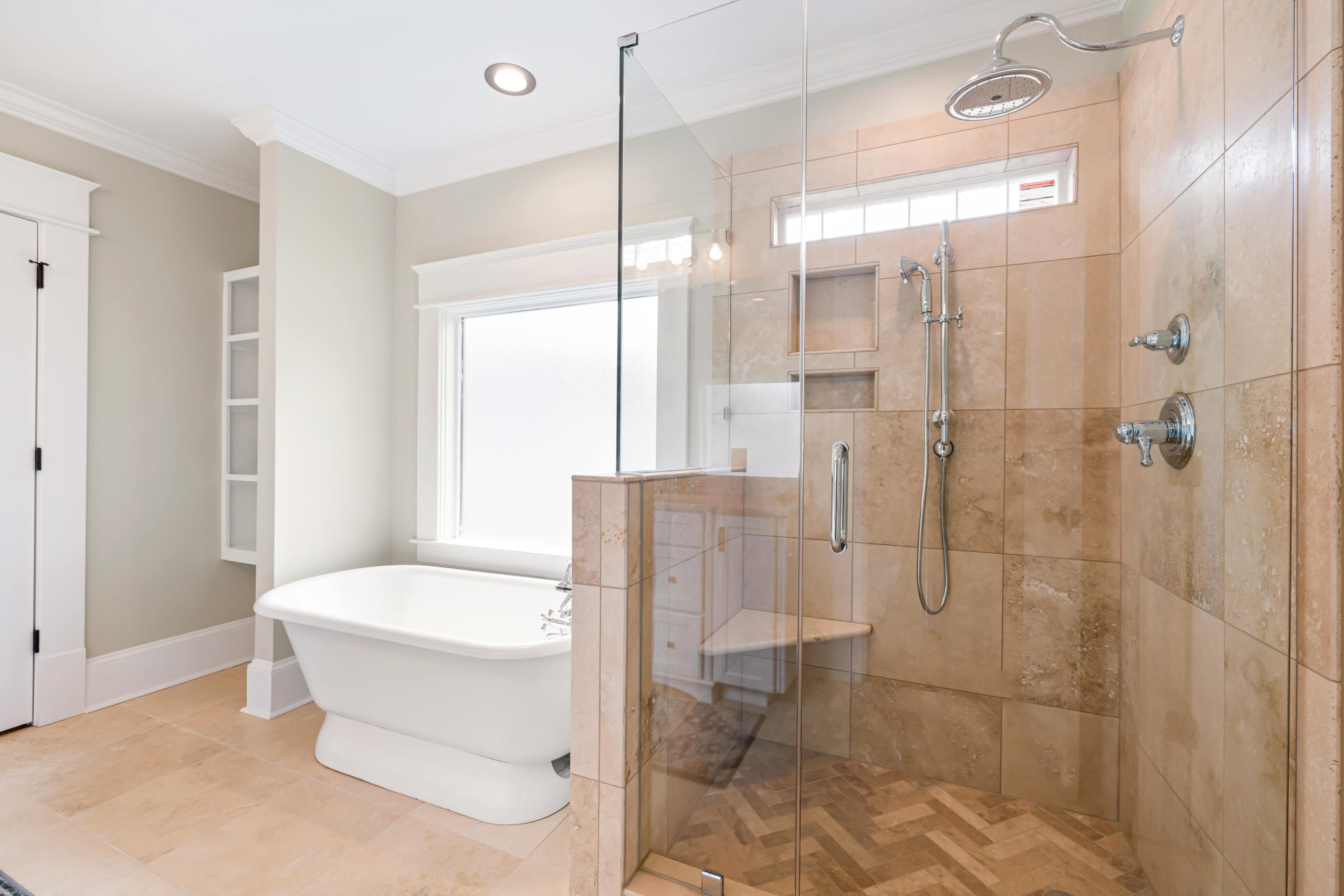Elegant bathroom with freestanding tub and glass shower enclosure.