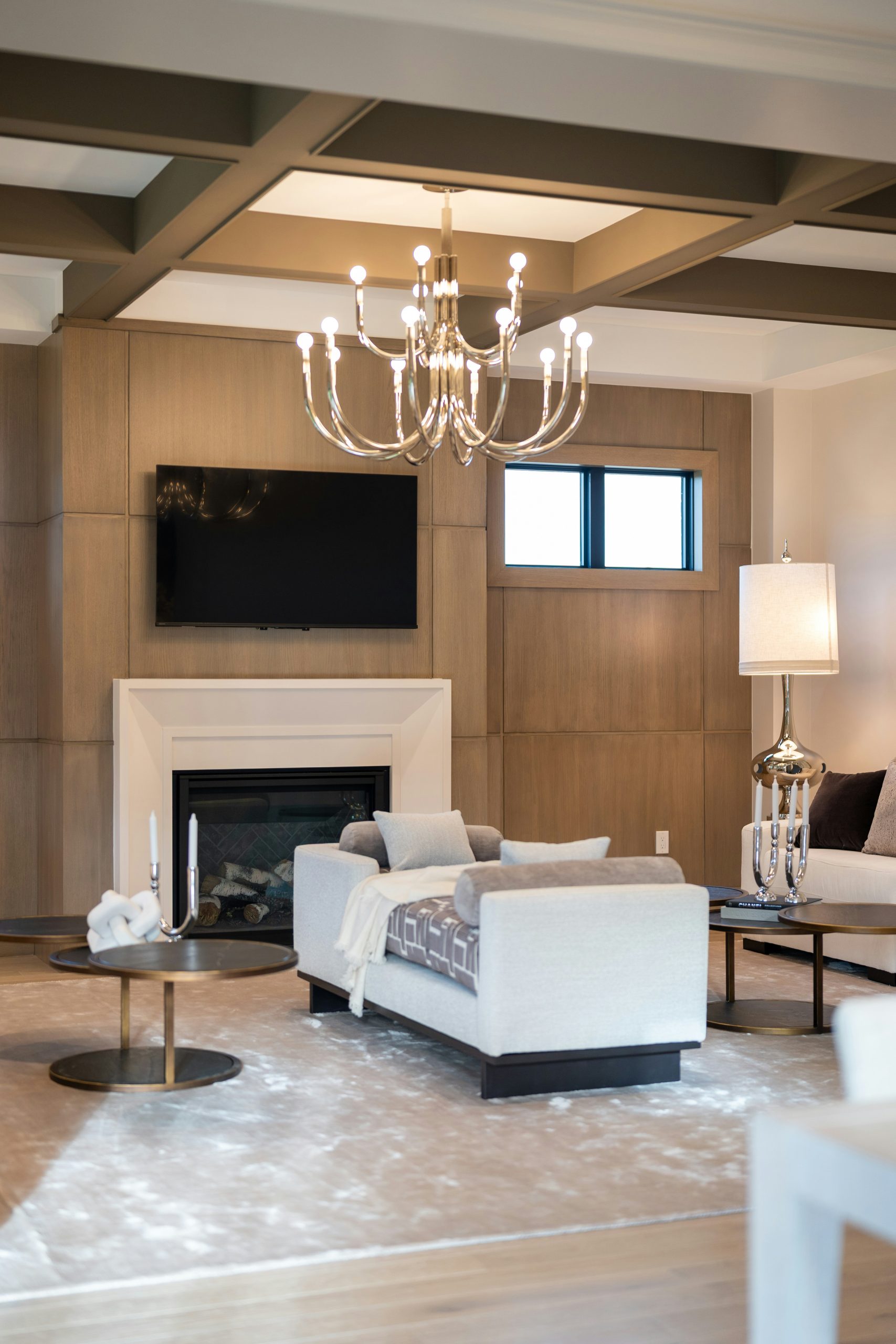 Elegant living room featuring a fireplace, tv, and stylish chandelier.