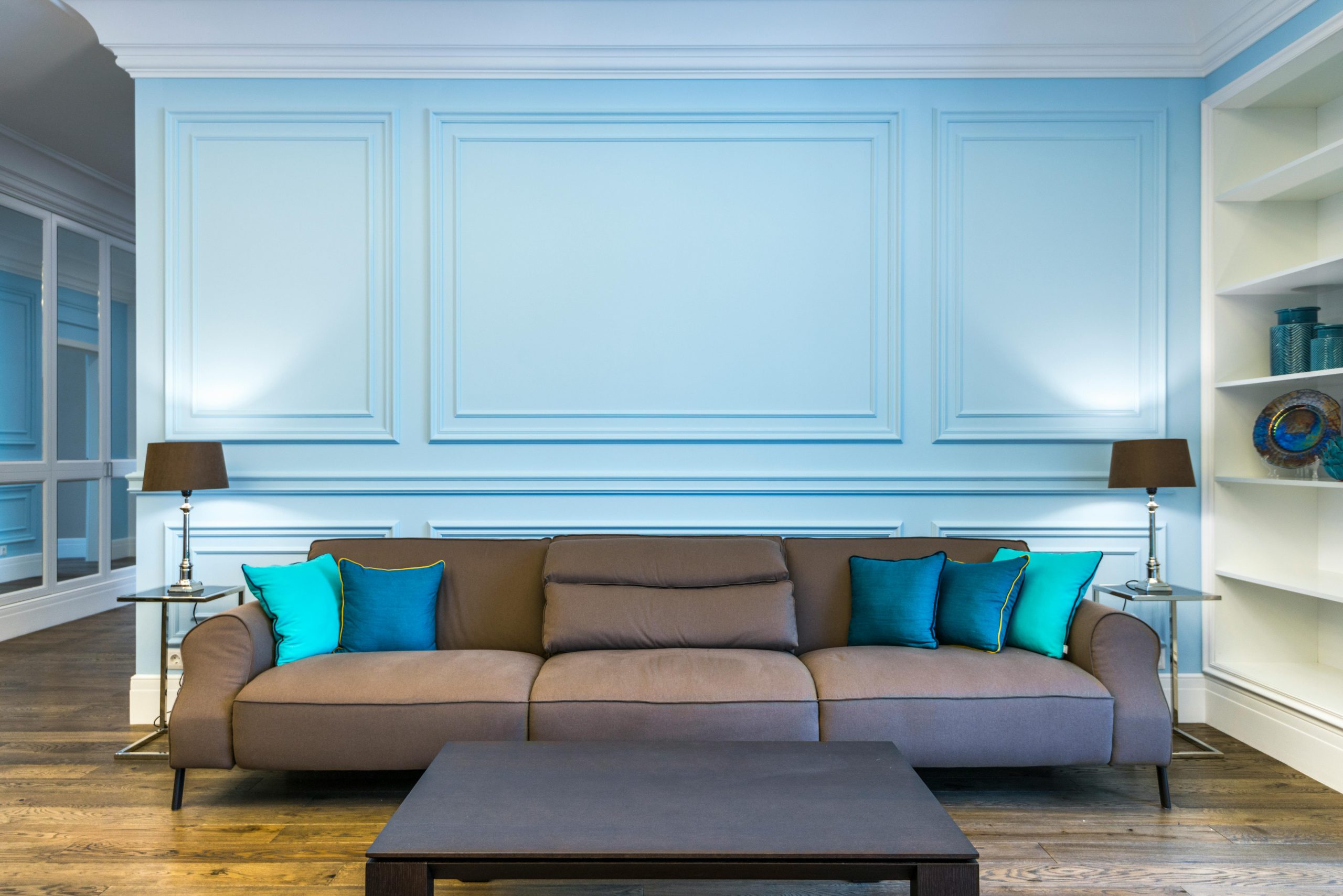 Elegant living room featuring a sleek brown sofa, blue accents, and modern decor.