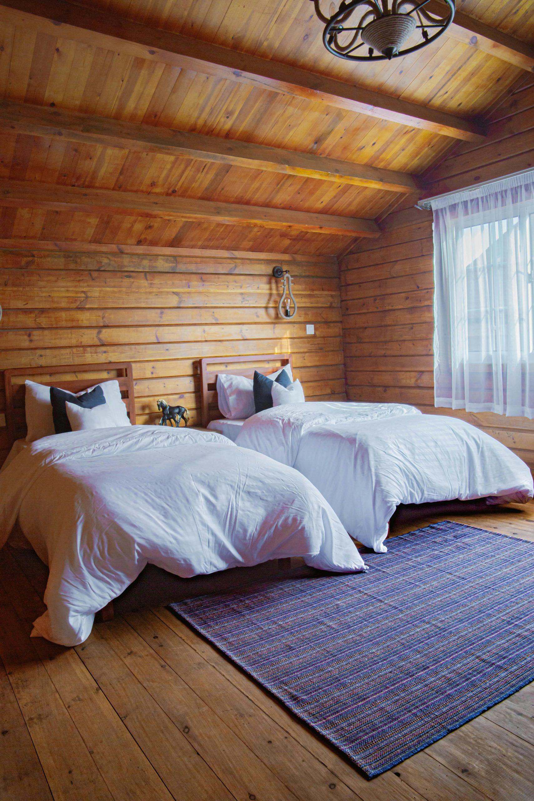 Inviting cabin bedroom with twin beds and rustic wooden interior design.