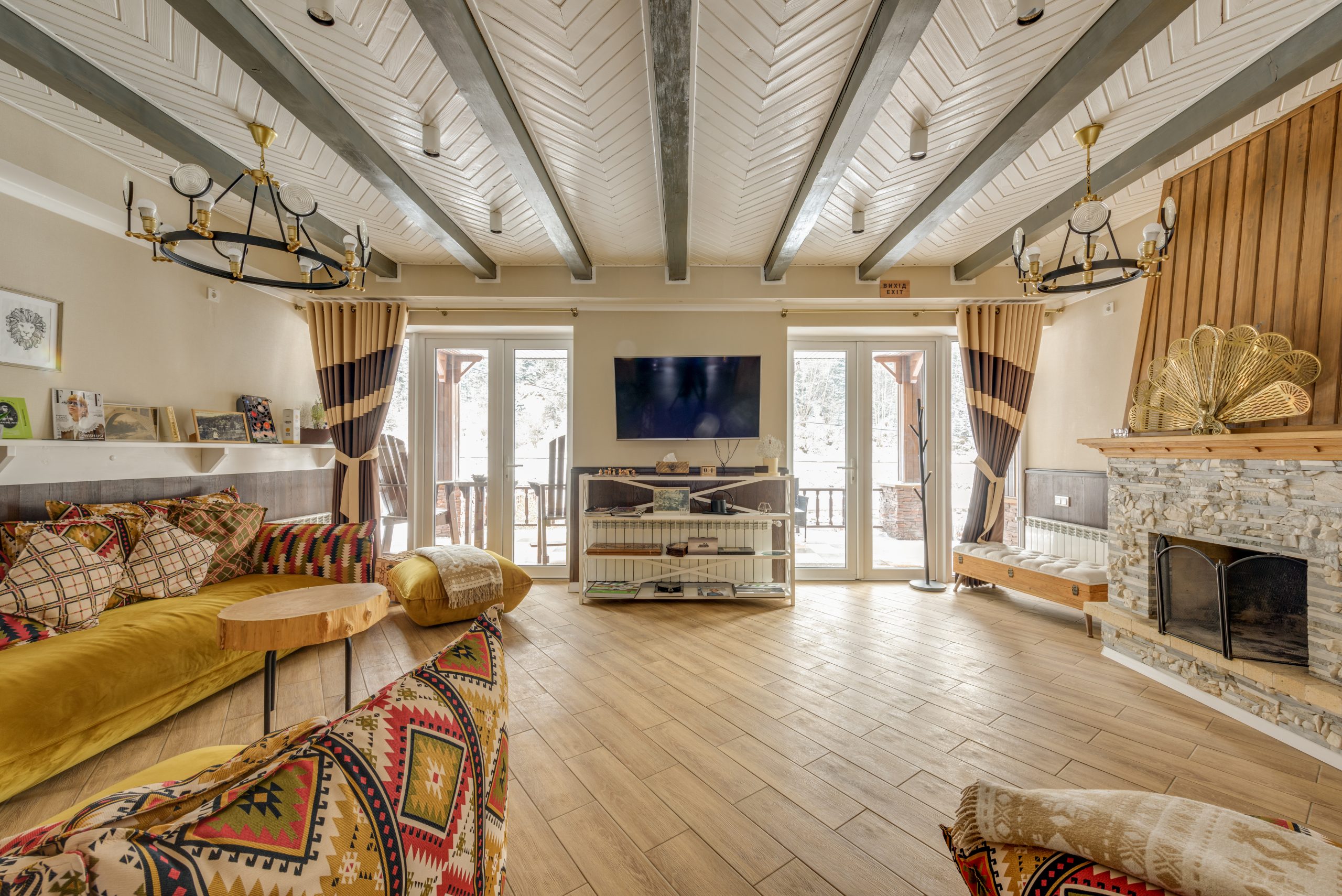 Inviting chalet interior with rustic decor and large stone fireplace, creating a warm atmosphere.