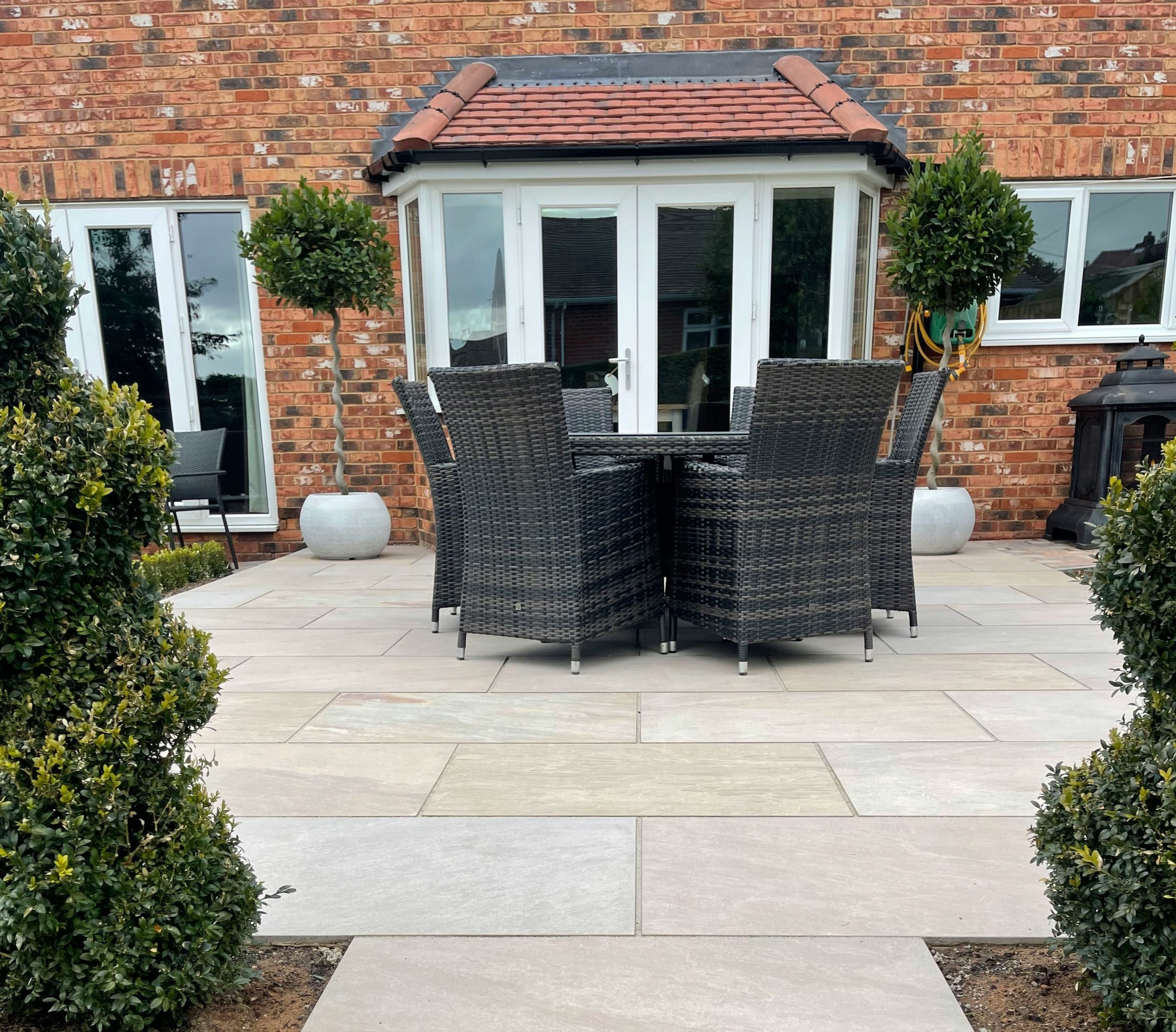 New build house landscaped garden patio with garden furniture and plants