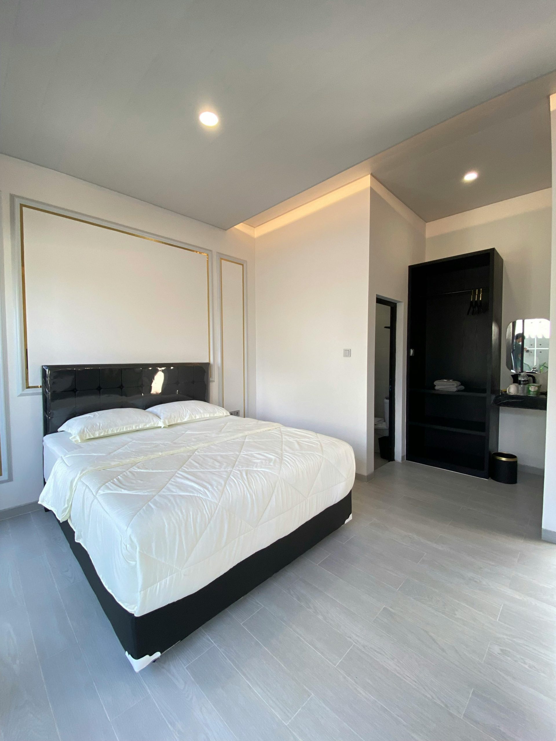 Spacious bright minimalist bedroom with modern decor and natural lighting.