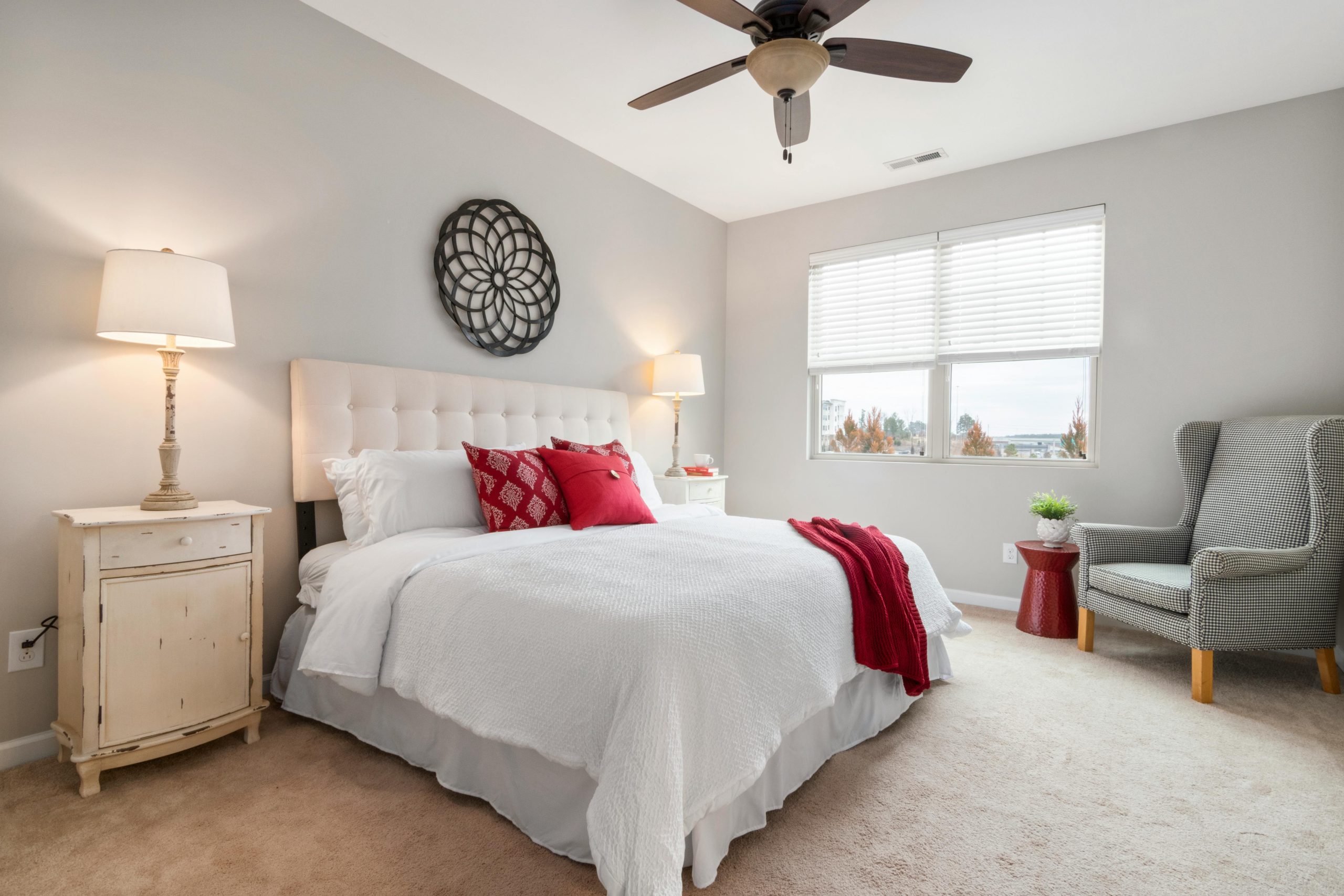 Spacious modern bedroom featuring cozy red accents and elegant decor.