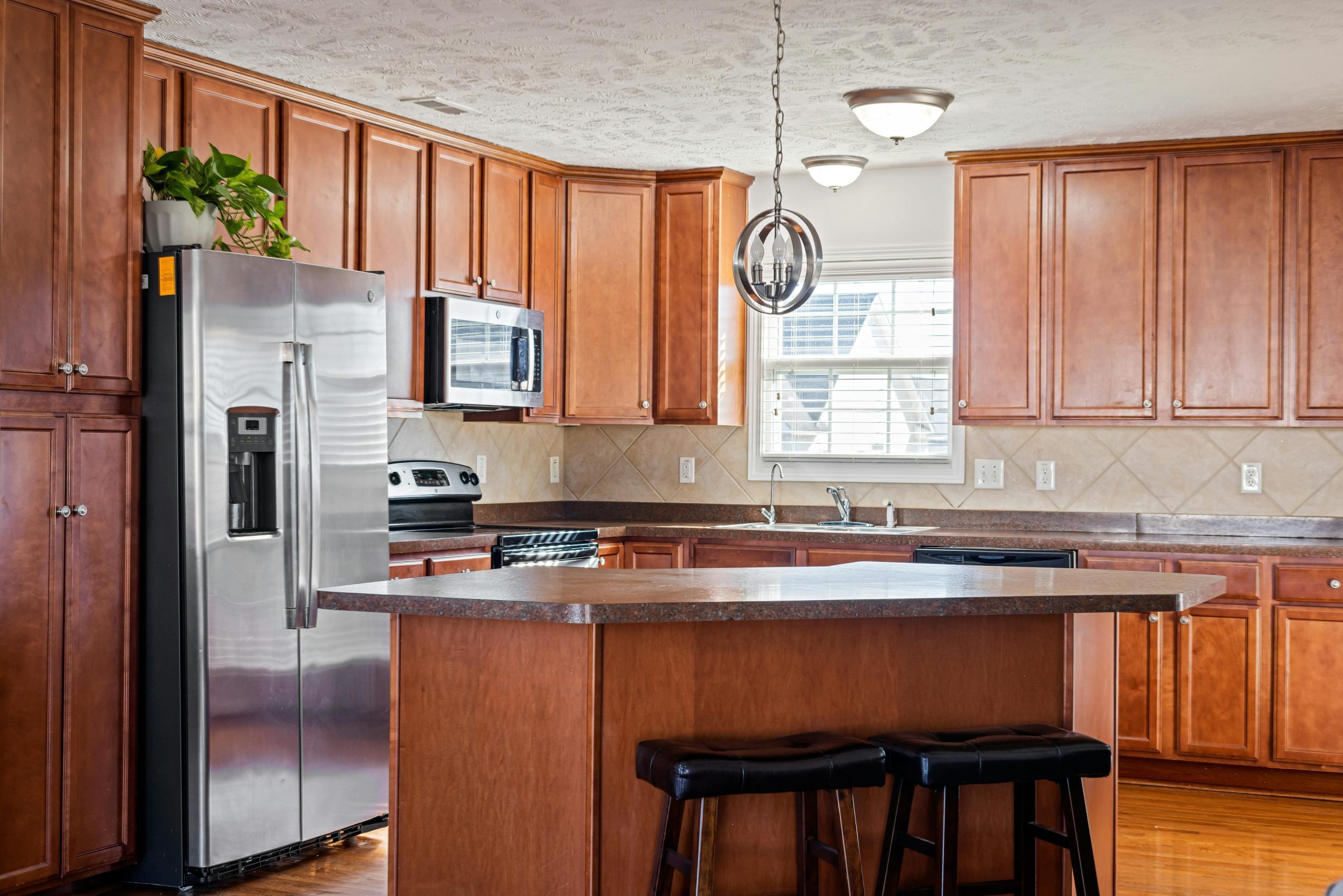Spacious modern kitchen interior featuring wooden cabinets and island.