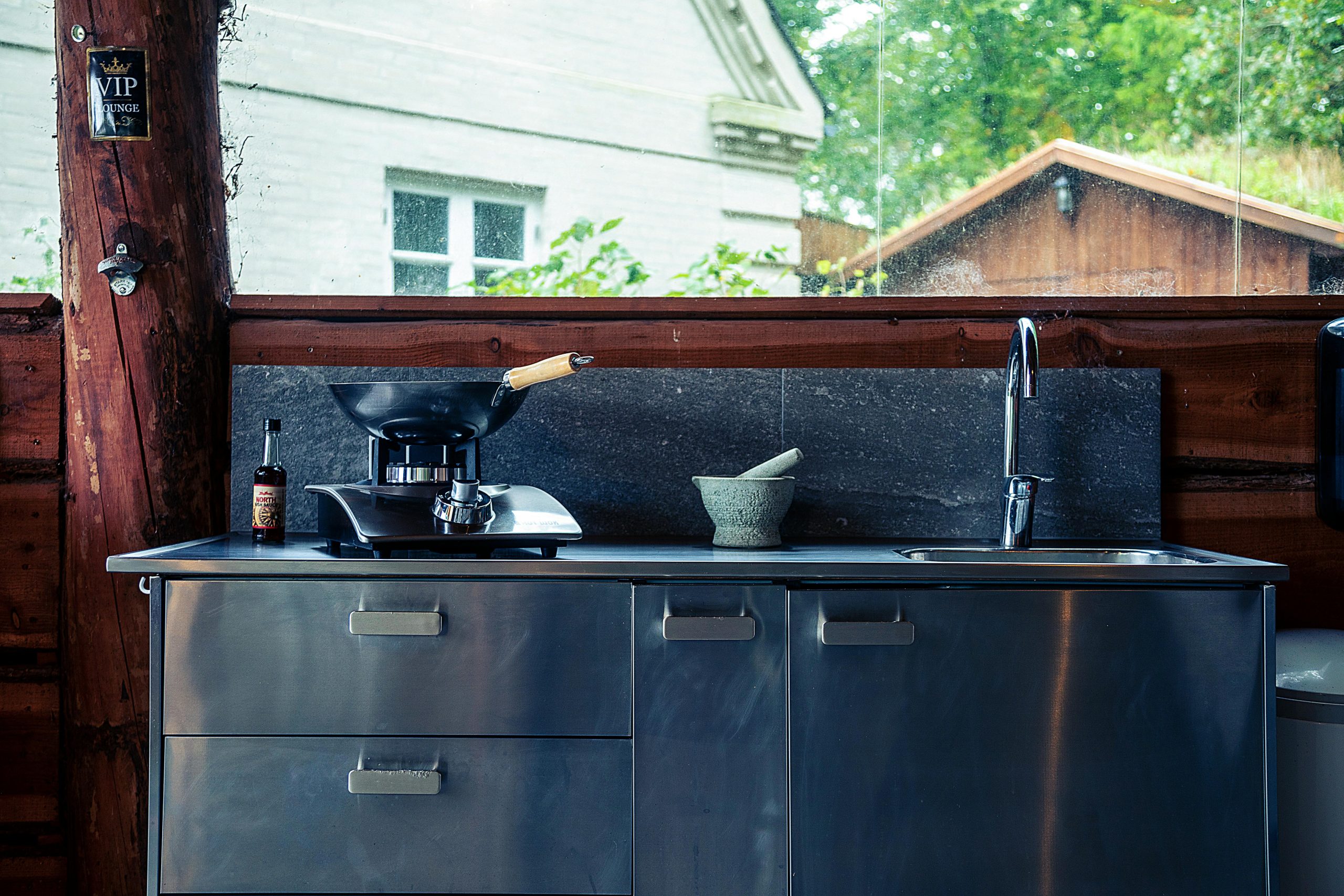 Stylish outdoor kitchen setup with a wok and sink, perfect for outdoor cooking enthusiasts.