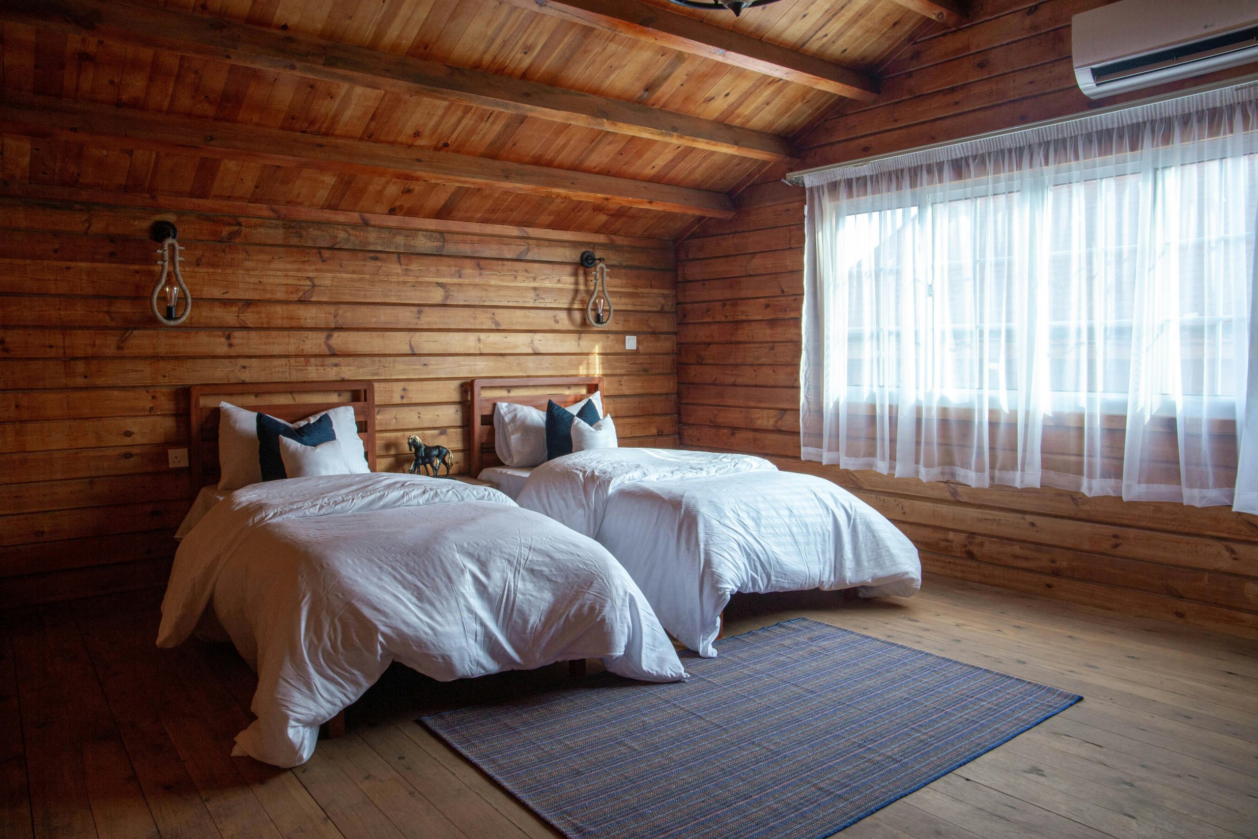 Warm and inviting log cabin bedroom with twin beds and rustic wooden walls.