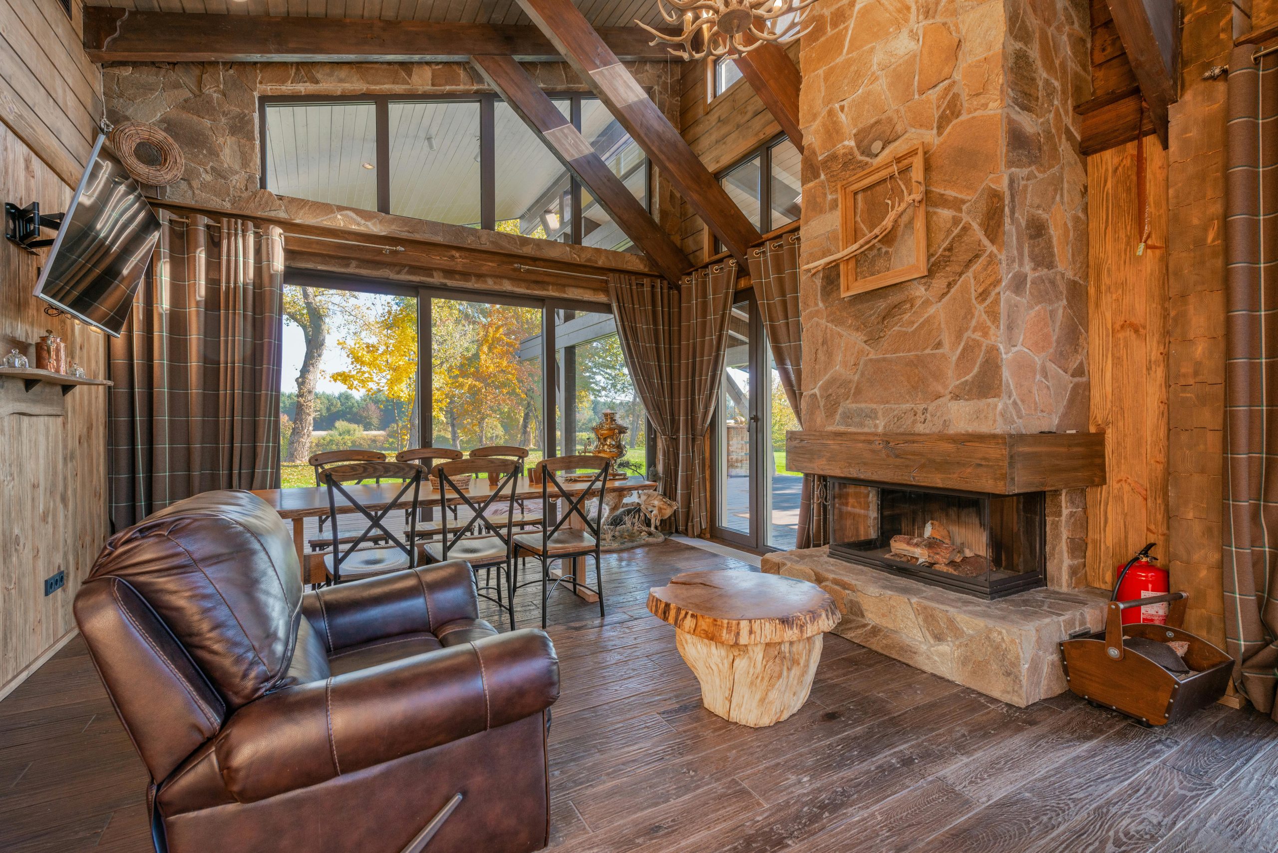 Warm and inviting rustic living room featuring leather couch and stone fireplace.