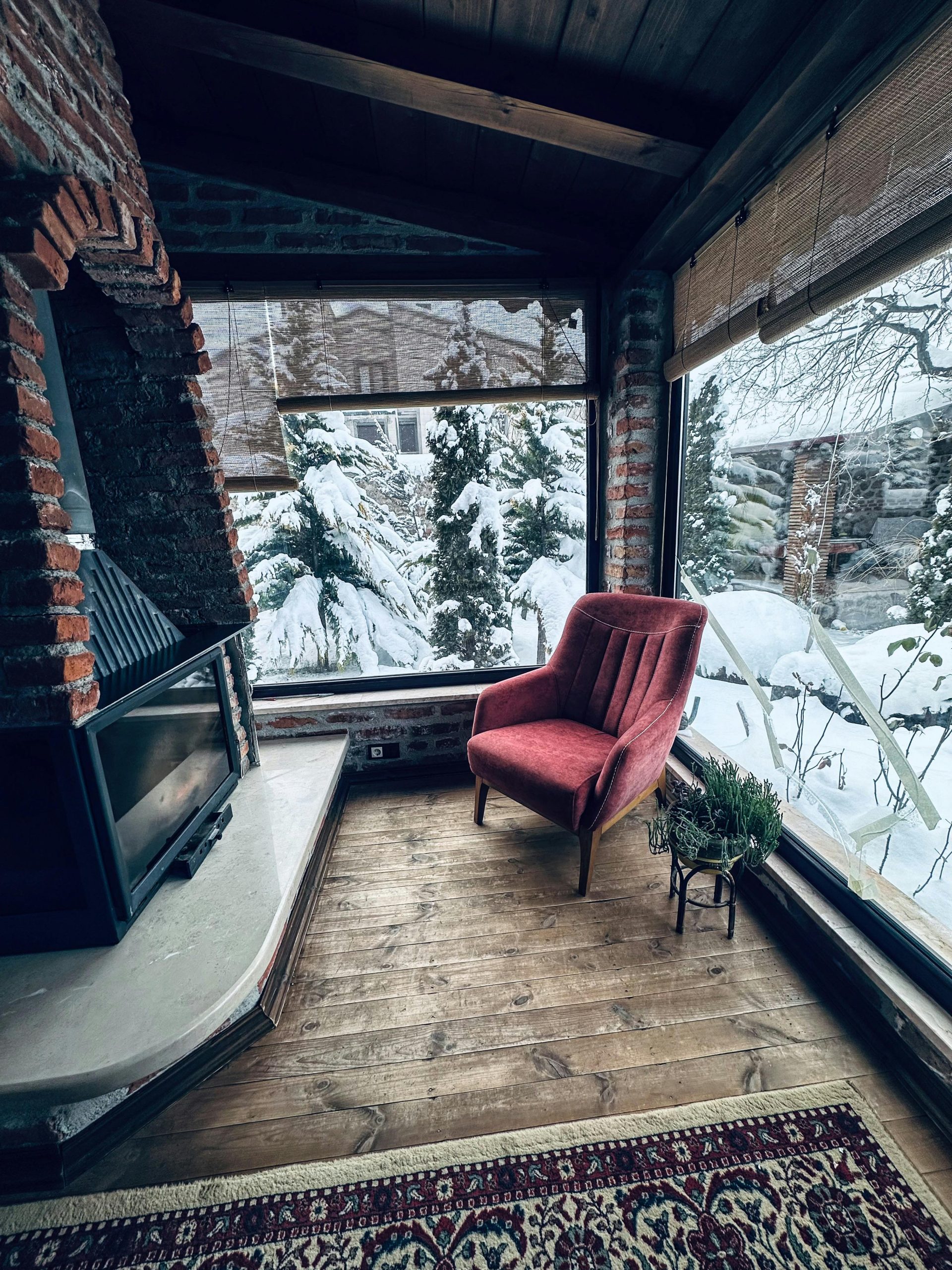 Warm interior featuring a fireplace and snowy outdoor view, perfect for winter relaxation.