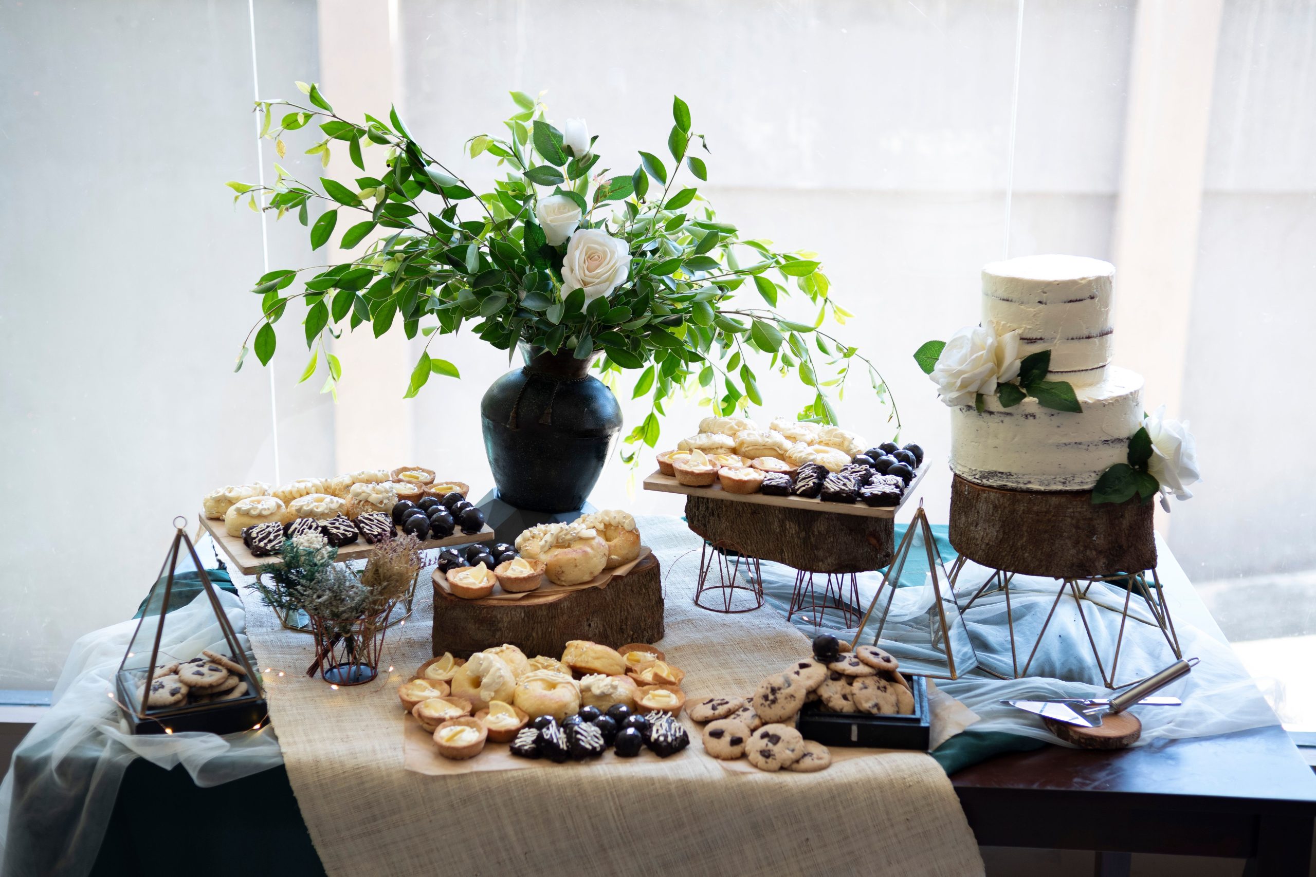 A beautifully arranged dessert table with pastries and a floral centerpiece, perfect for special occasions.