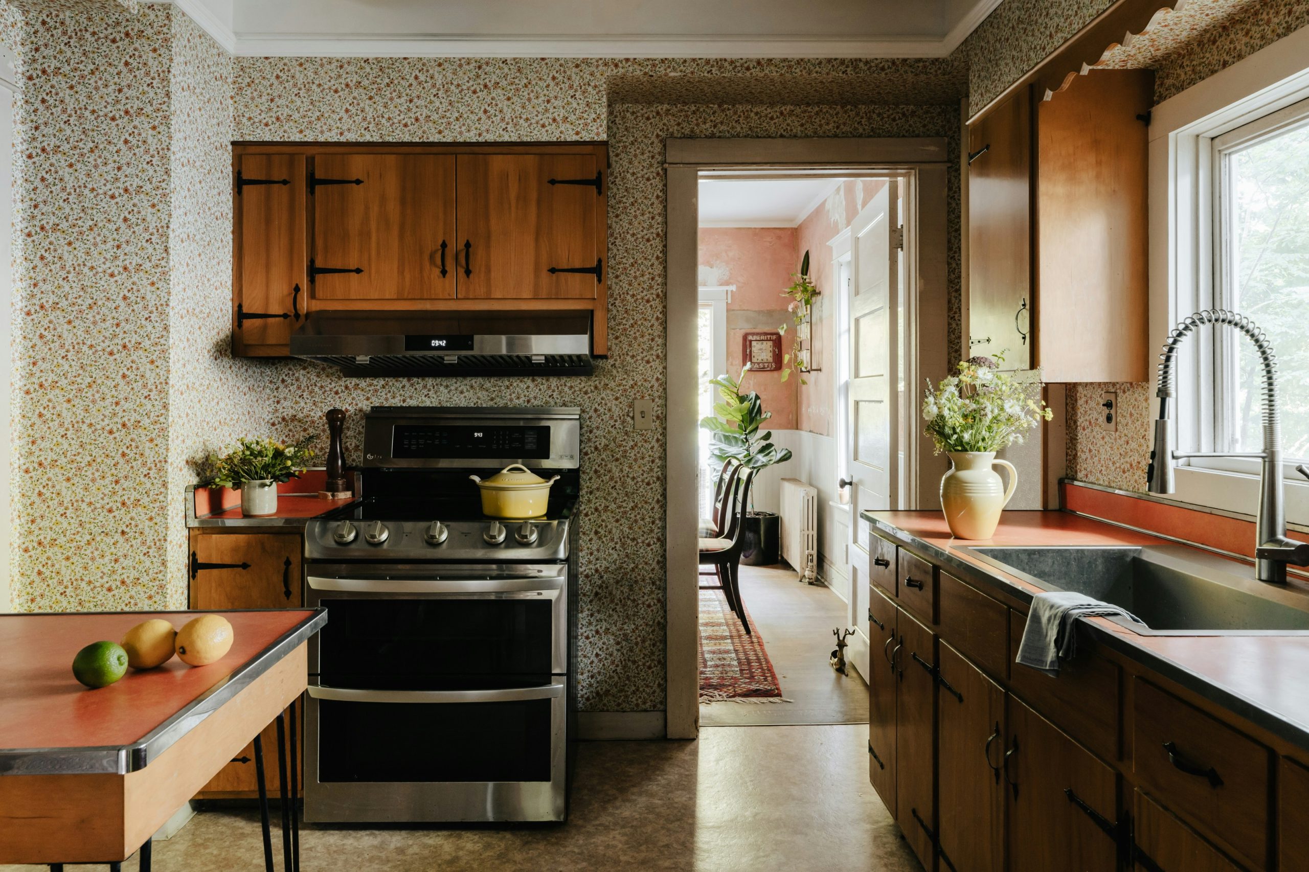 A kitchen with a stove, sink, and refrigerator