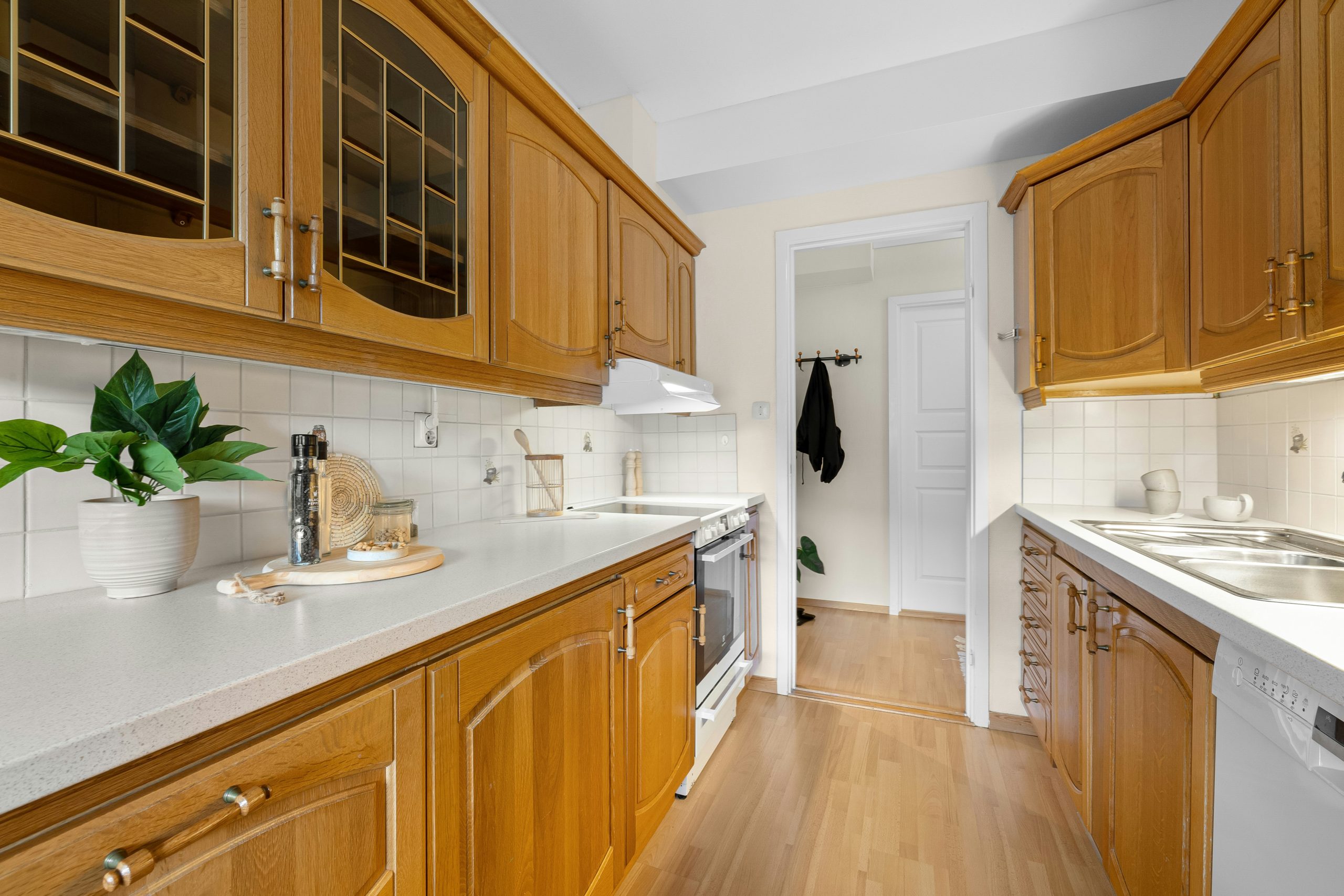 A kitchen with wooden cabinets and white counter tops