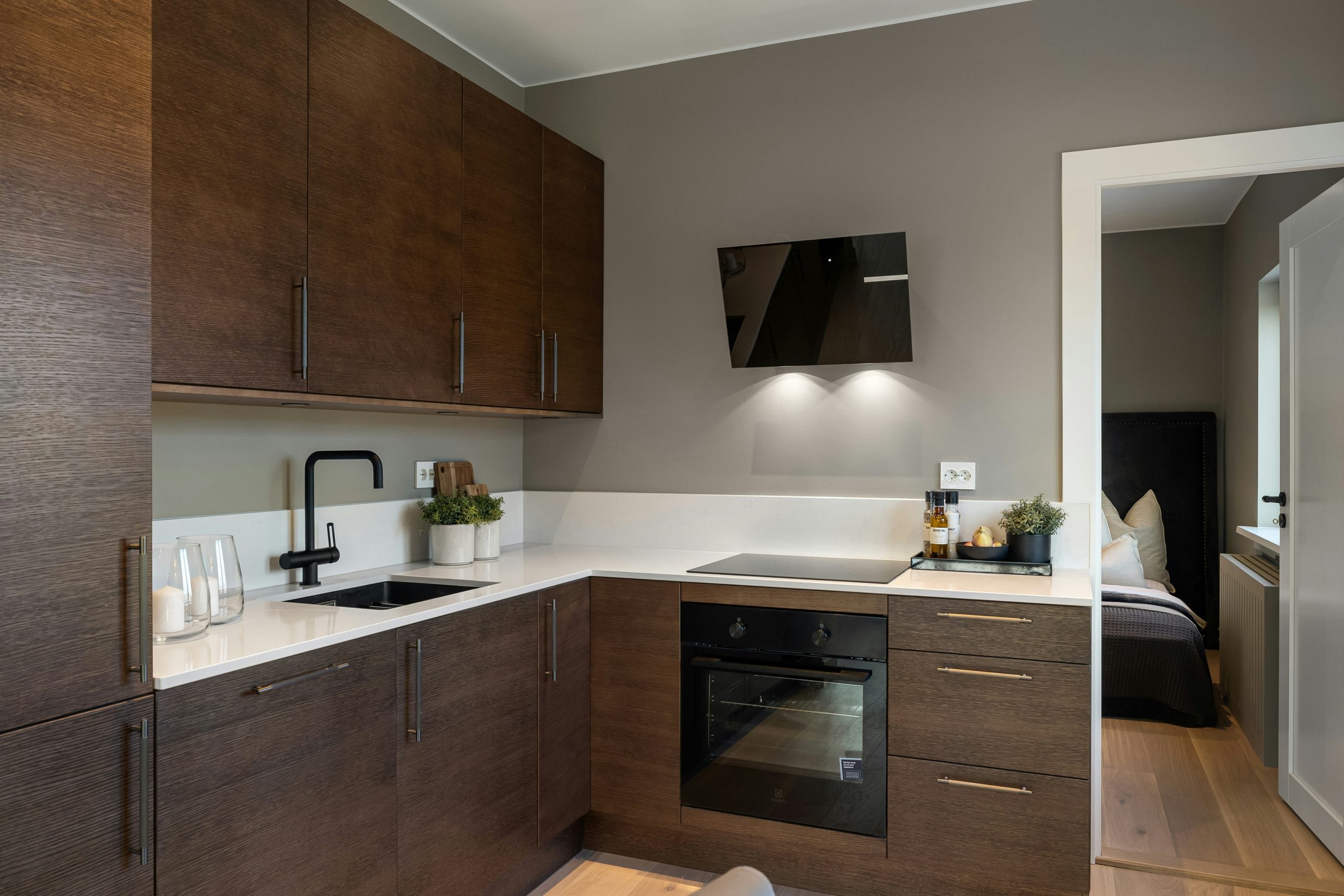 A kitchen with wooden cabinets and white counter tops