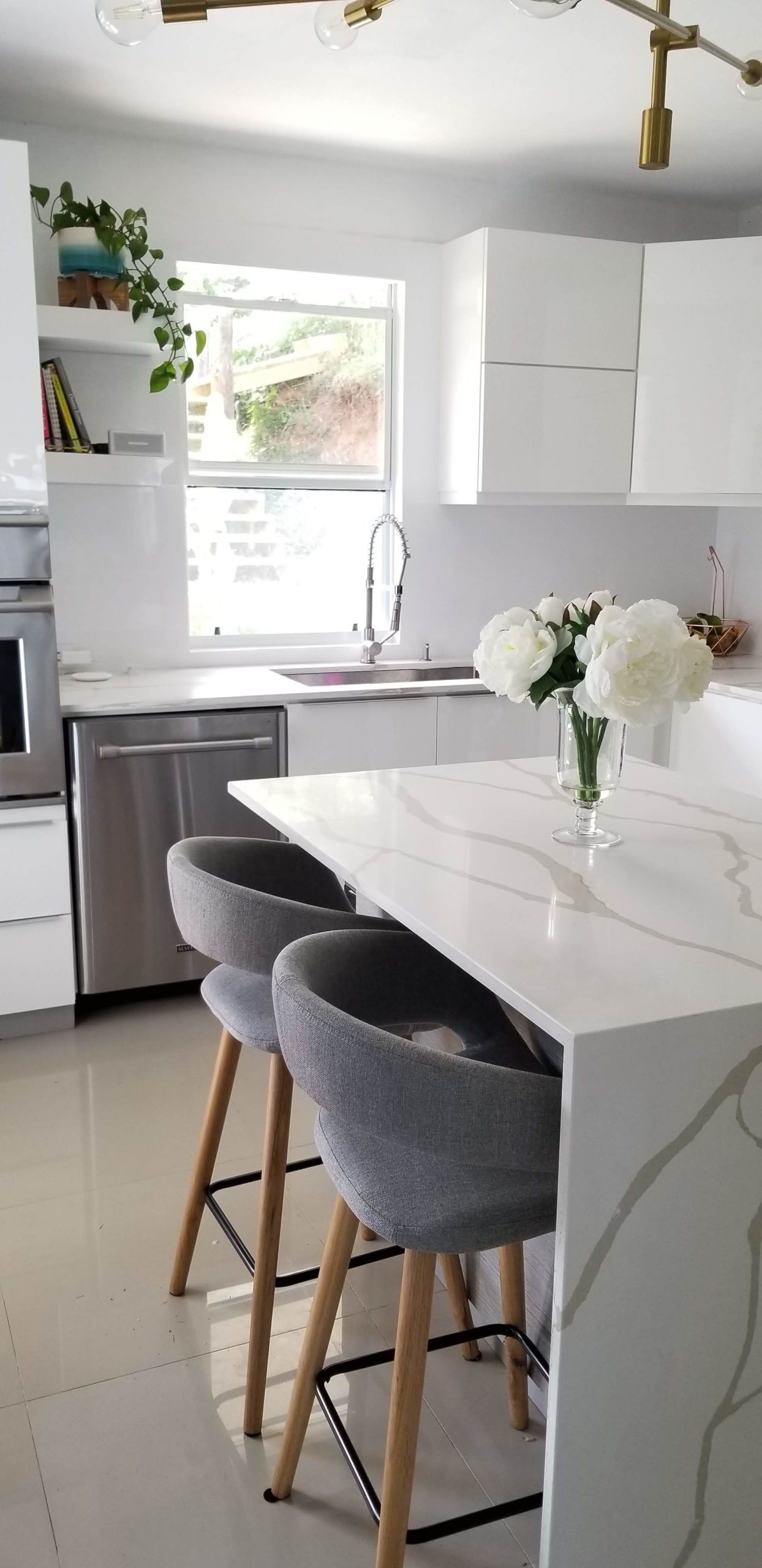 A sleek and modern kitchen featuring a white marble island and stylish decor.