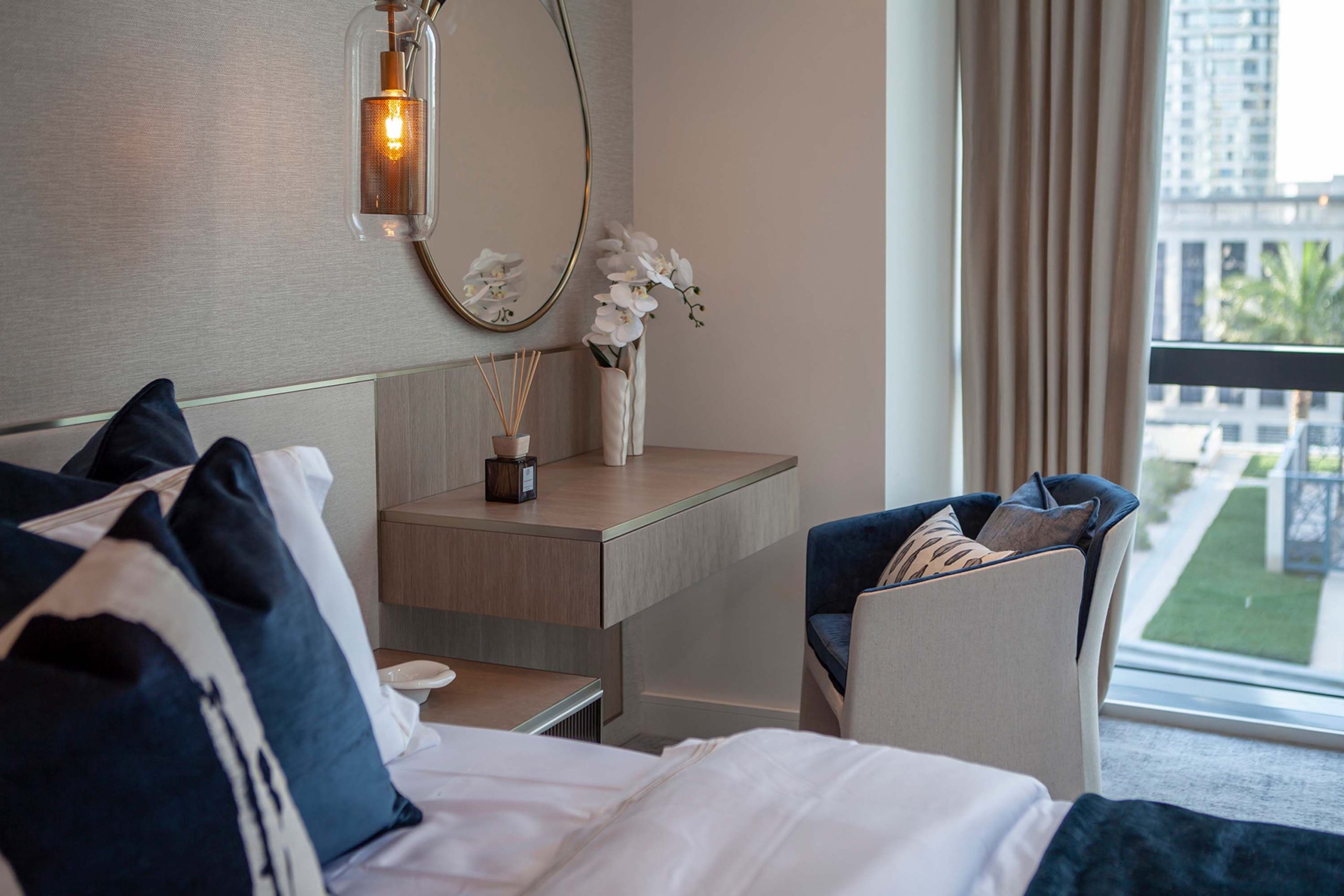 A stylish bedroom featuring modern design and a serene city view.