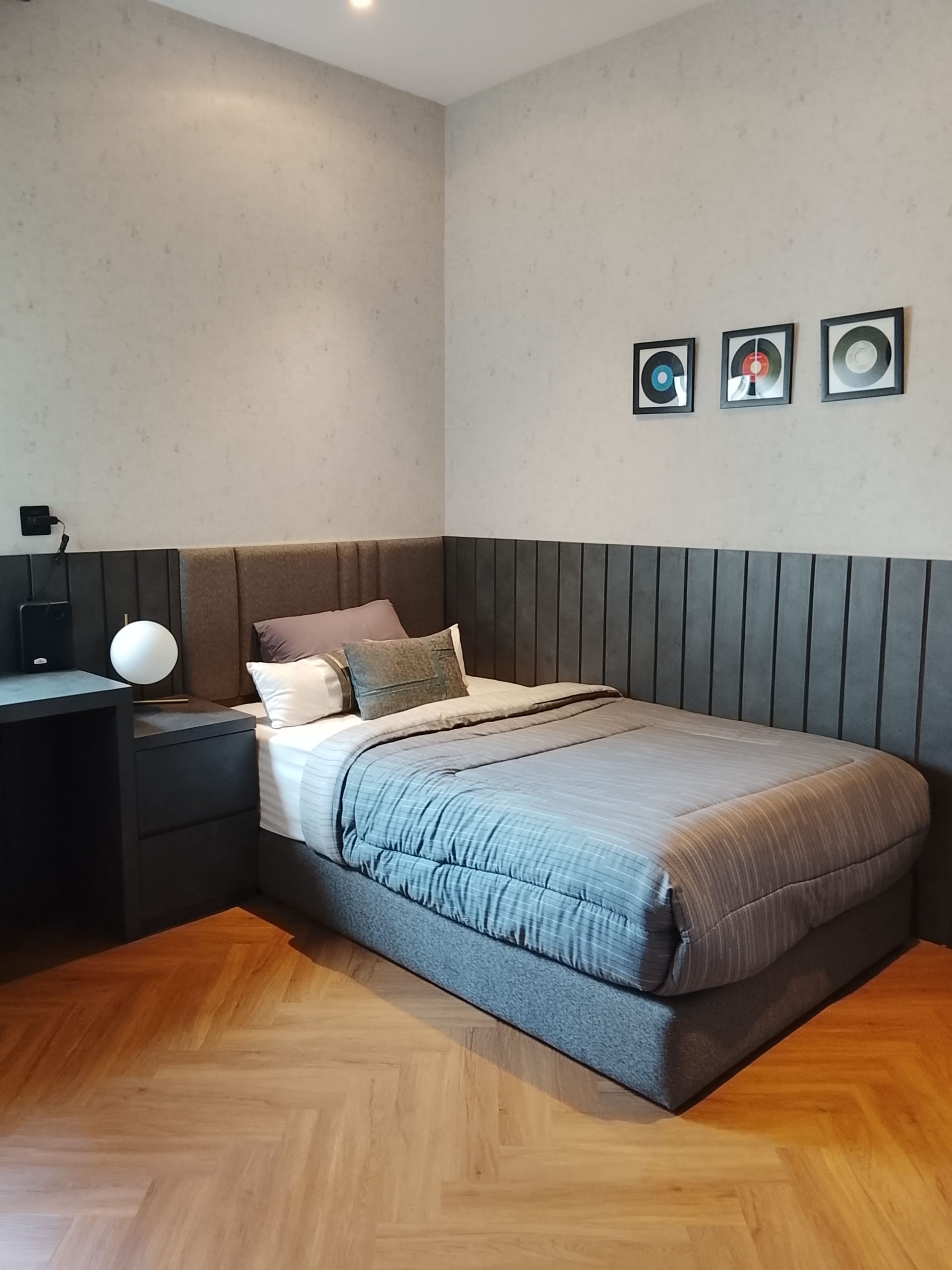 A stylish modern bedroom with gray tones and a wooden floor in Jakarta, Indonesia.