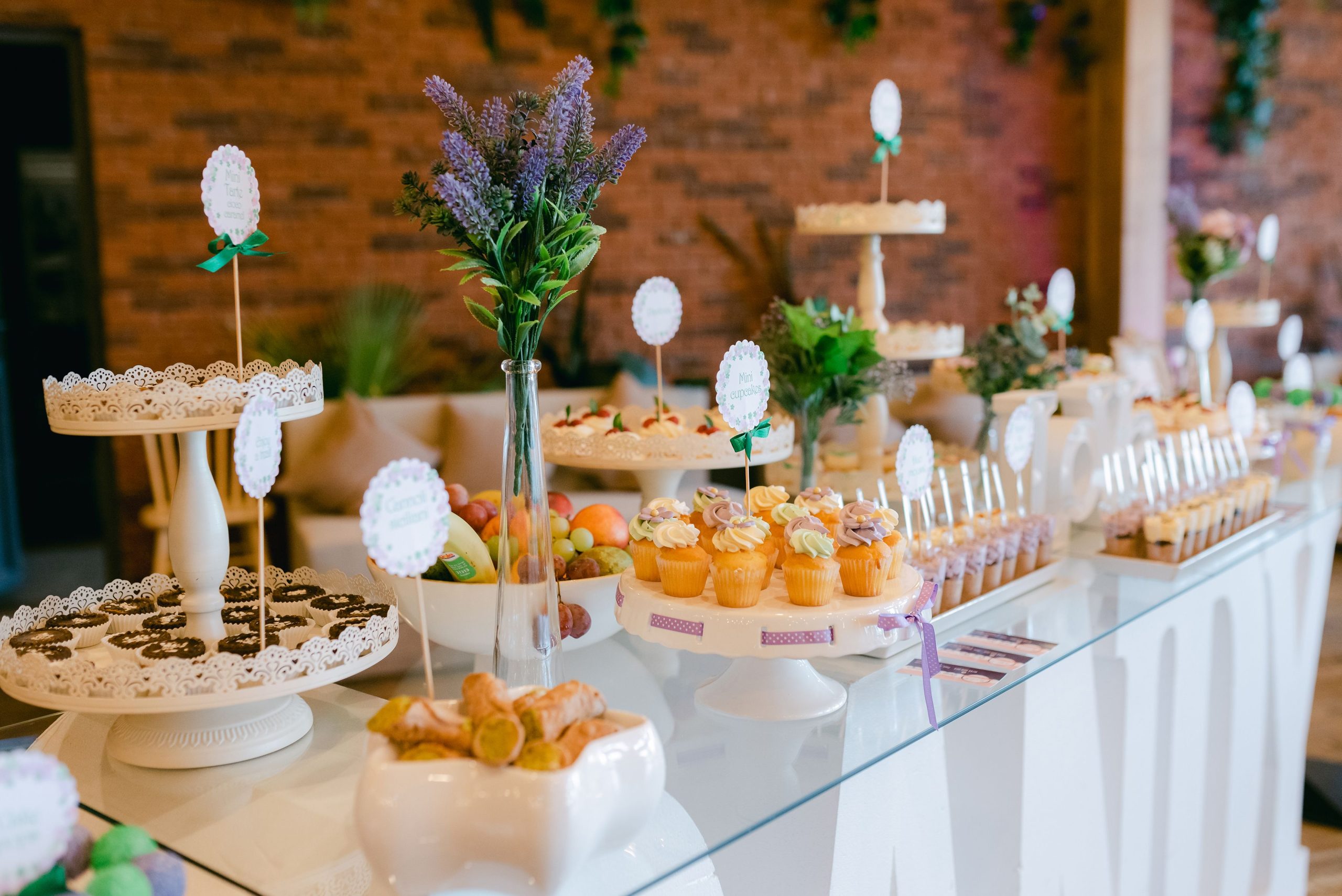 Beautifully arranged dessert table with pastries, cupcakes, and flowers for a special event.