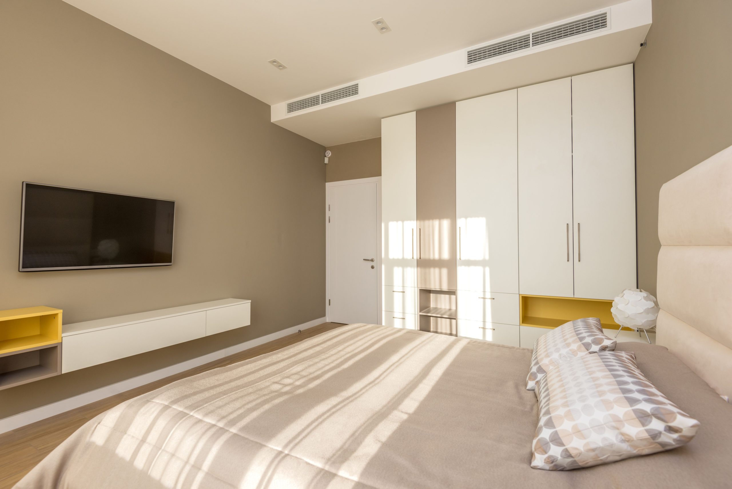 Bright and spacious modern bedroom with neutral tones and elegant decor.