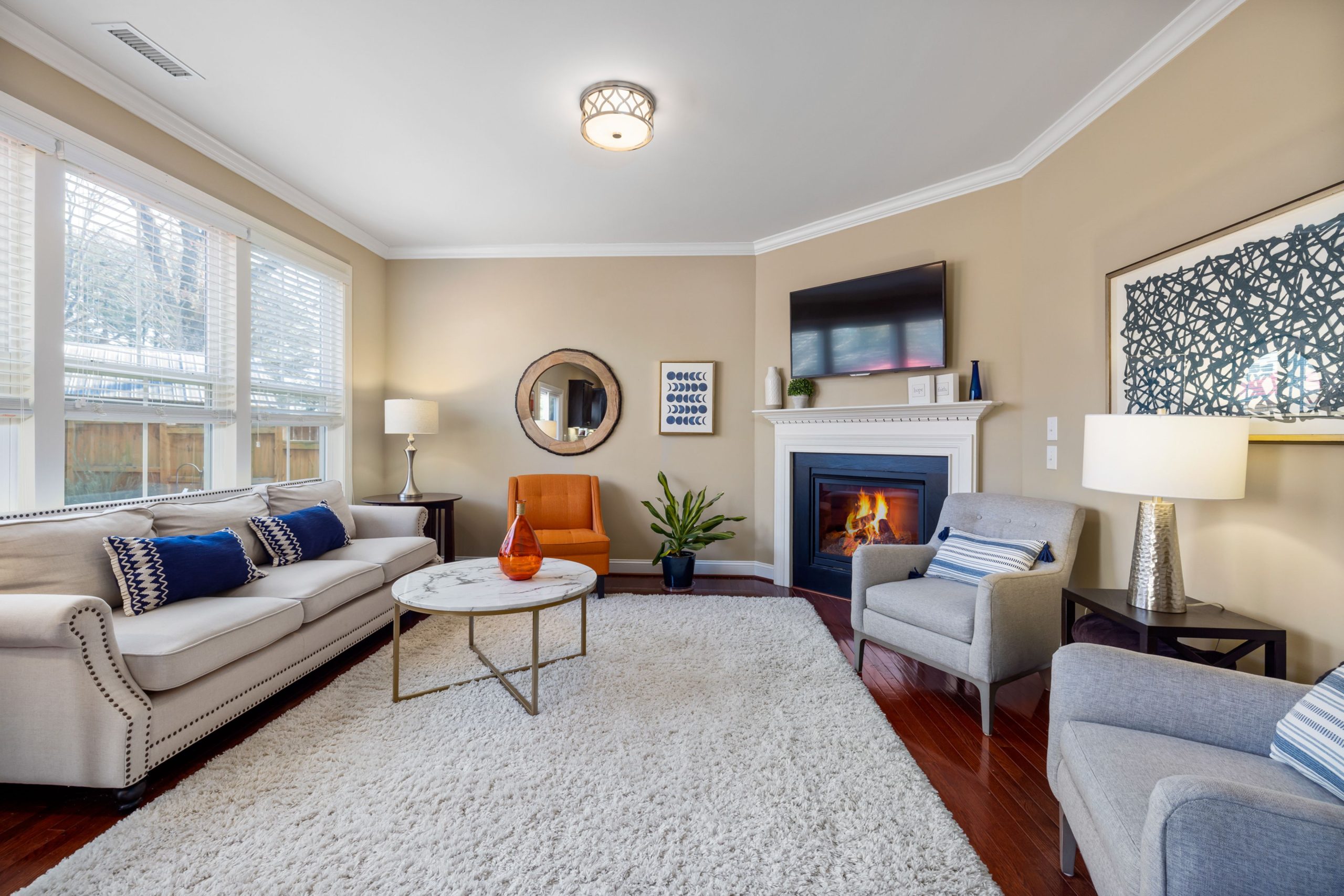 Bright living room featuring a cozy fireplace, elegant armchairs, and contemporary decor.