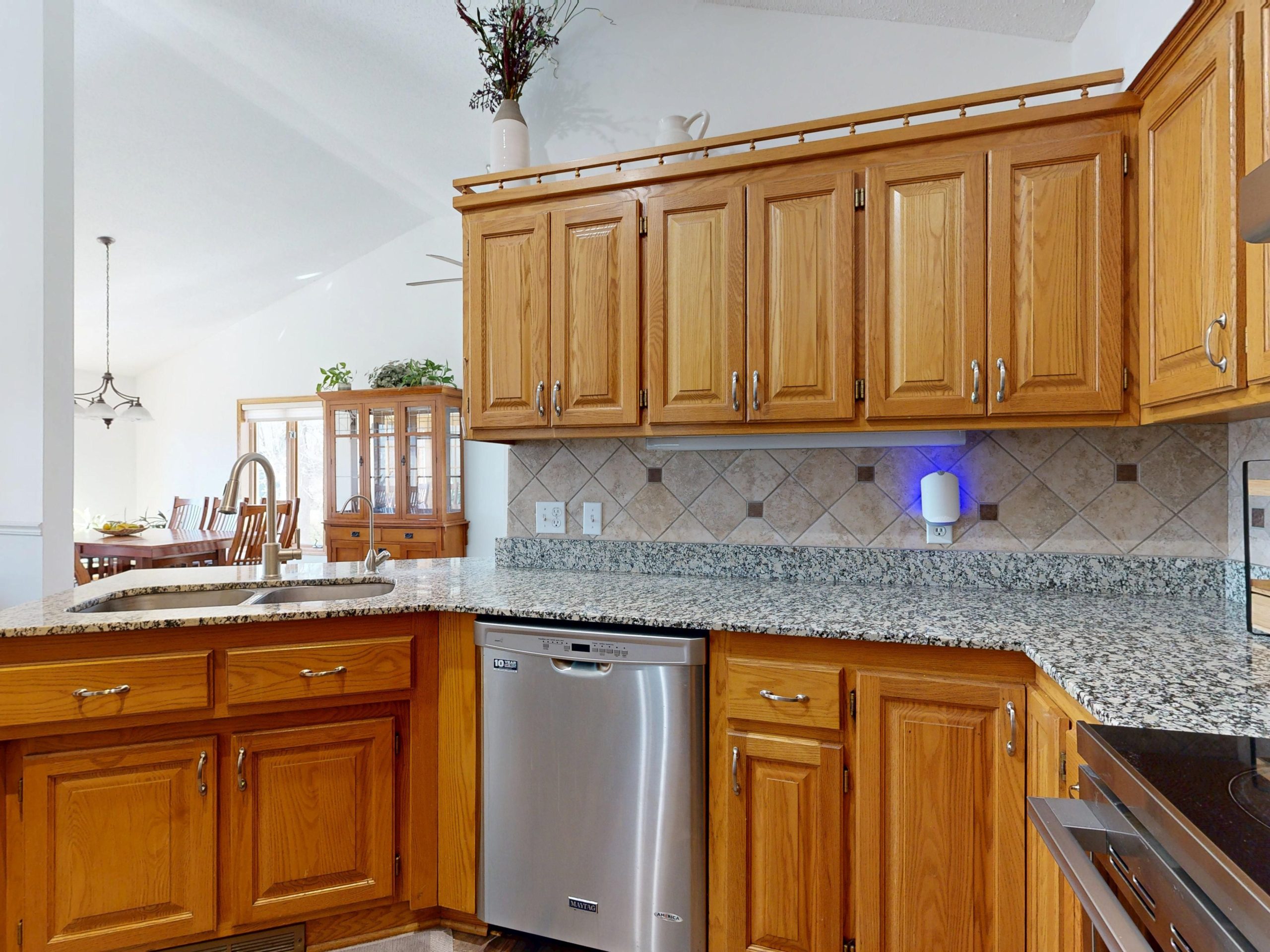 Bright modern kitchen showcasing wooden cabinets and granite countertops.