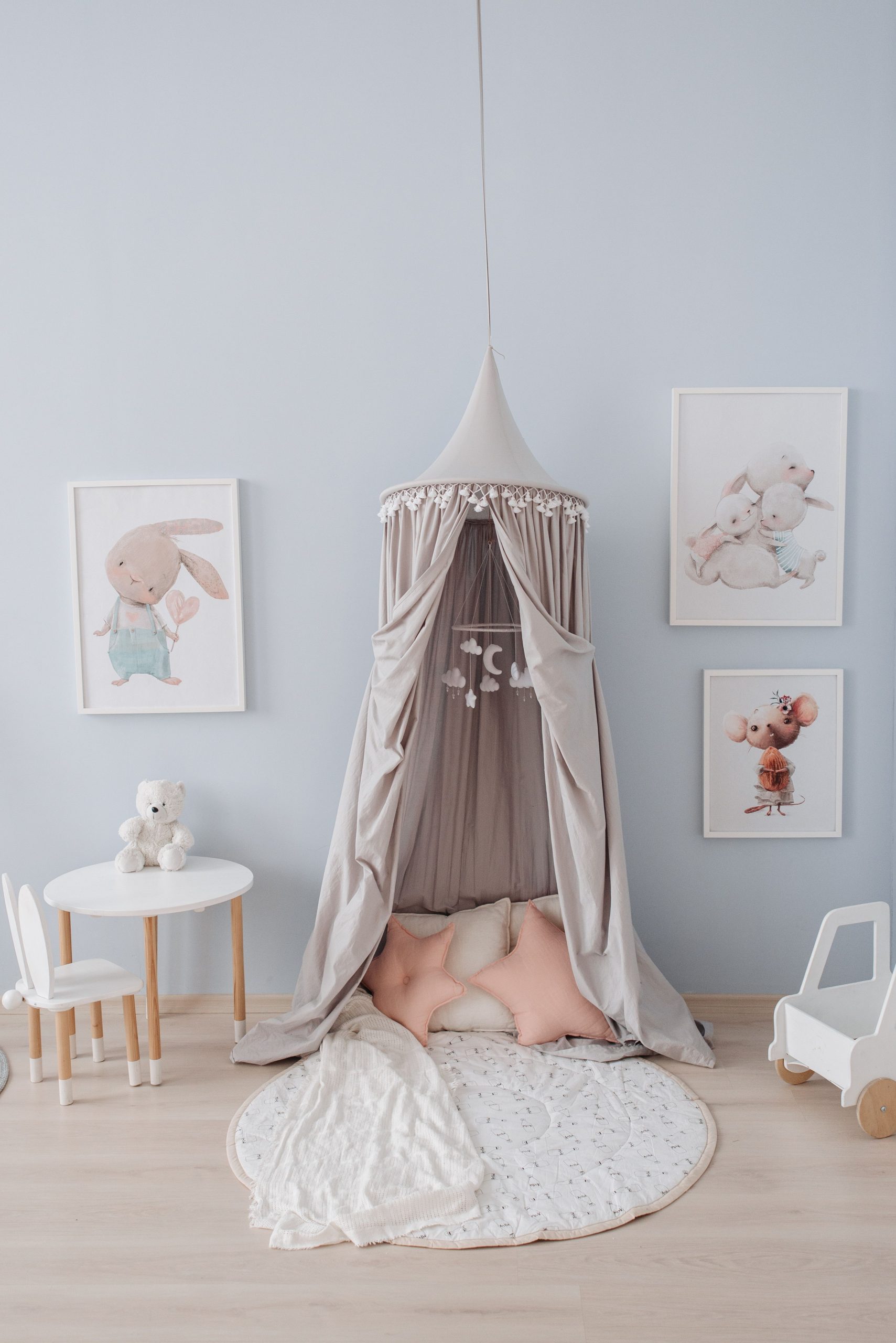 Charming nursery room with a soft play canopy, toys, and adorable animal art.