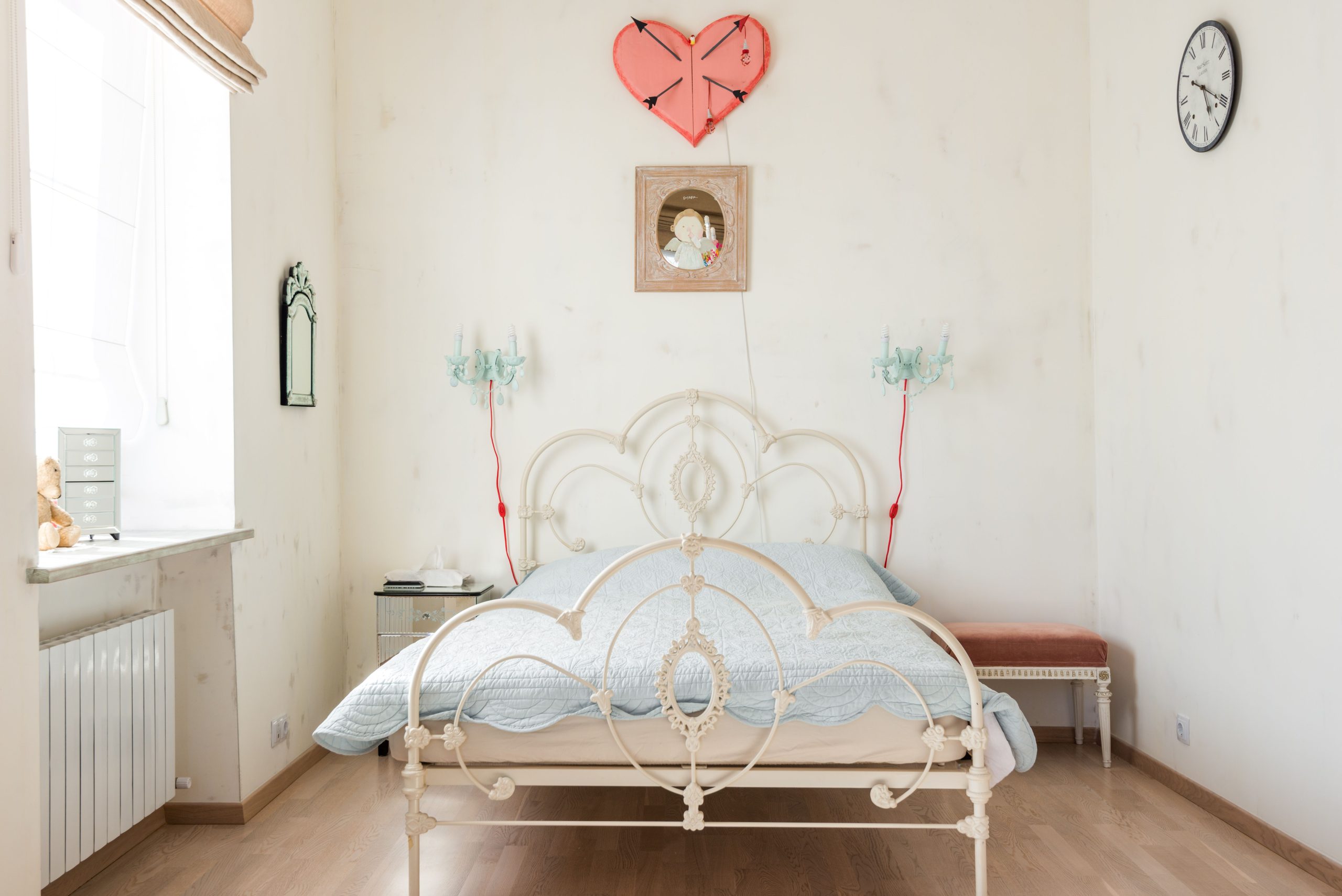 Charming vintage bedroom decor with an antique iron bed and pastel tones, perfect for cozy interiors.