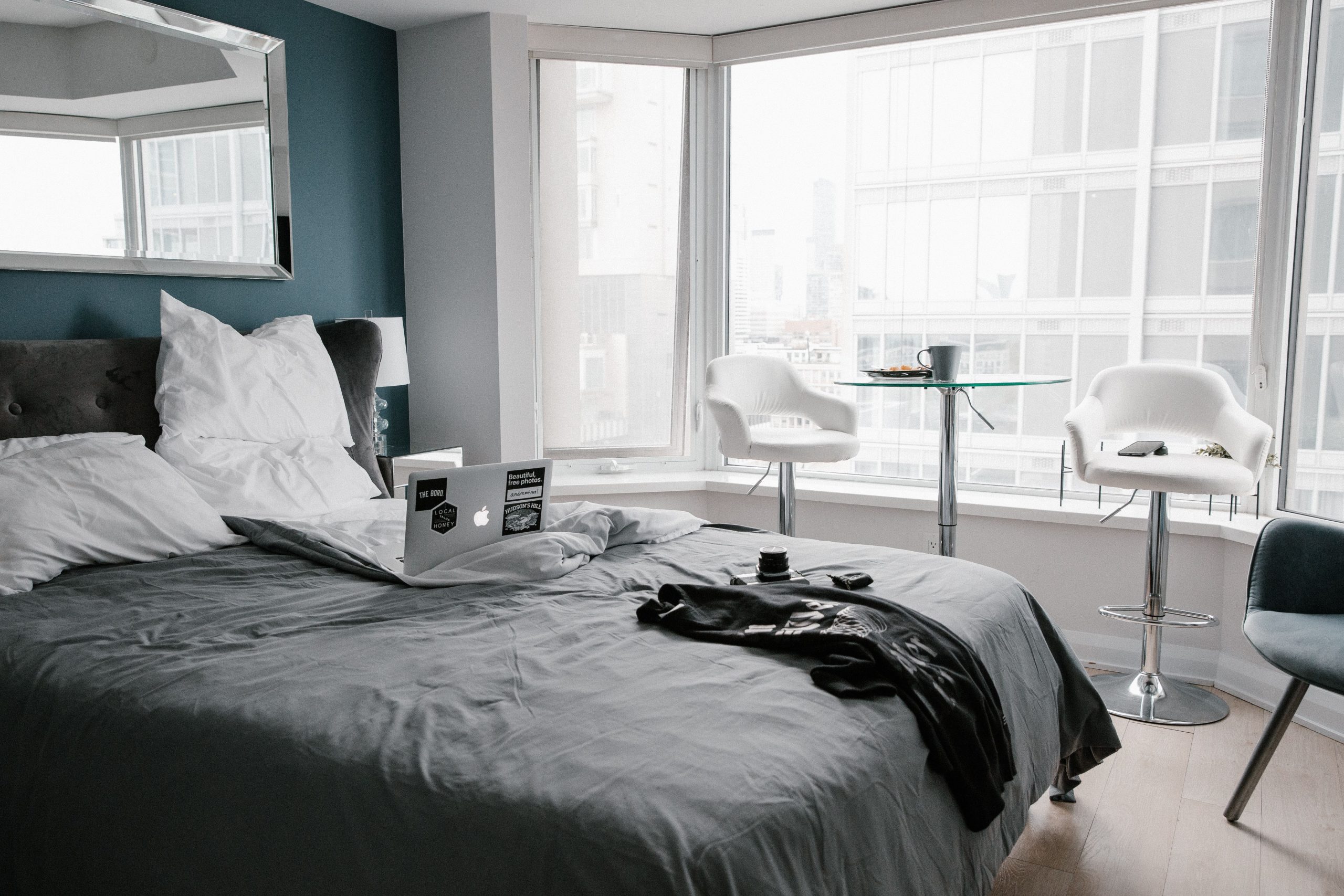 Contemporary hotel room in Toronto with bed, laptop, and city view.