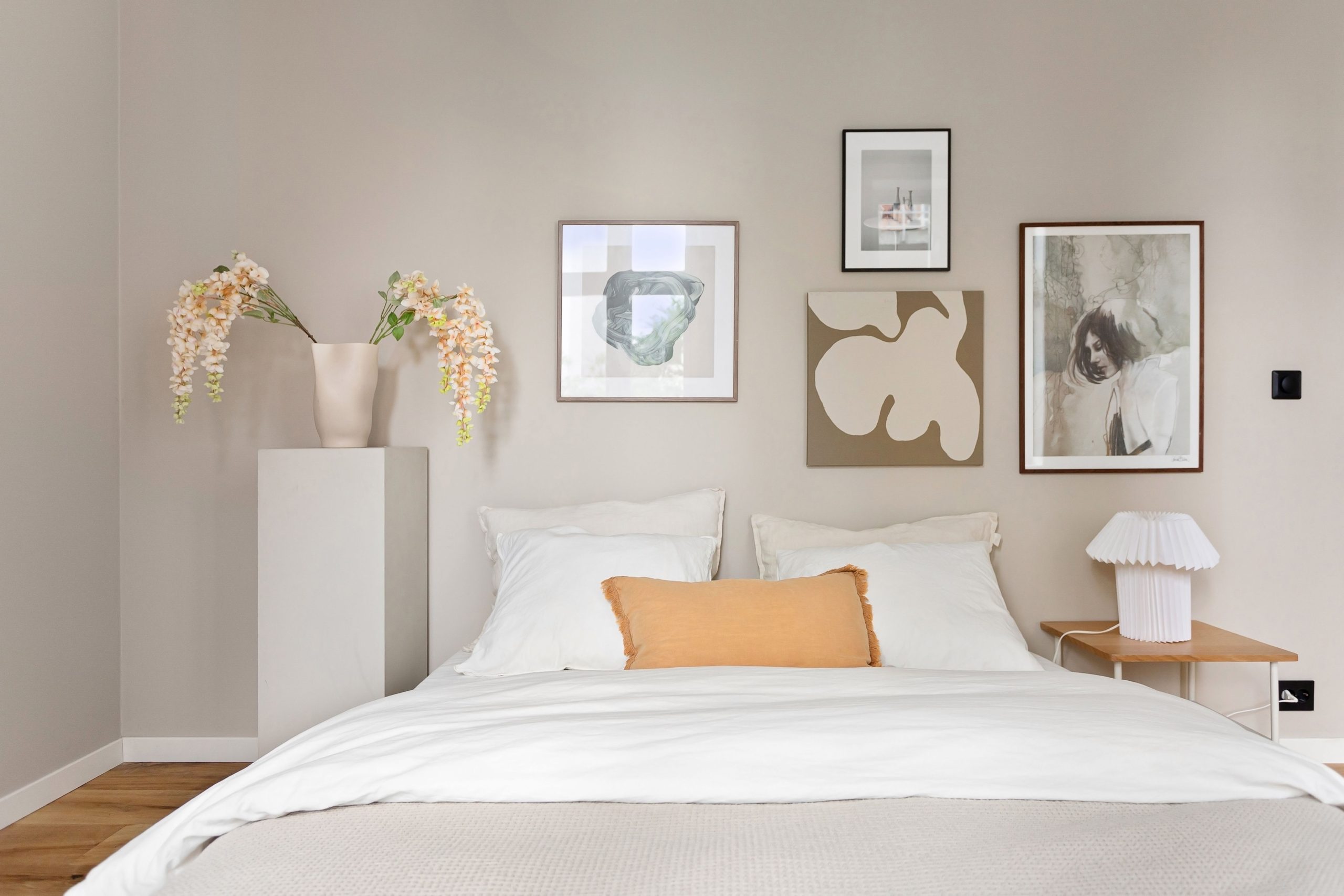 Elegant minimalist bedroom with modern artwork and decor, exuding calmness.