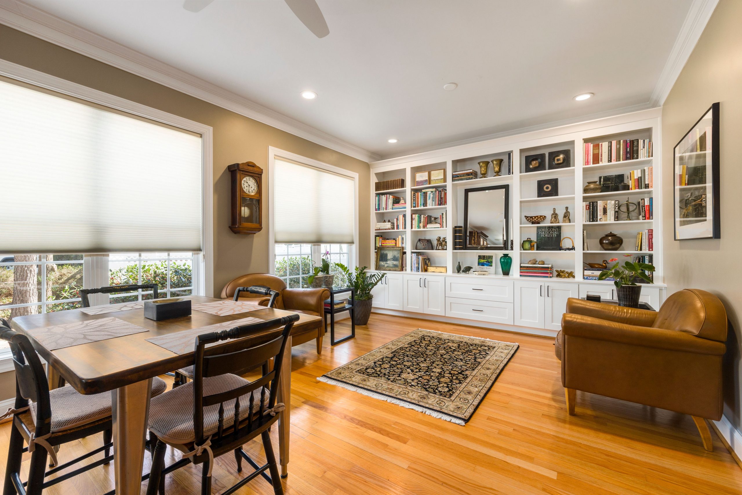 Luxurious living room featuring a large bookshelf, cozy armchairs, and natural light.