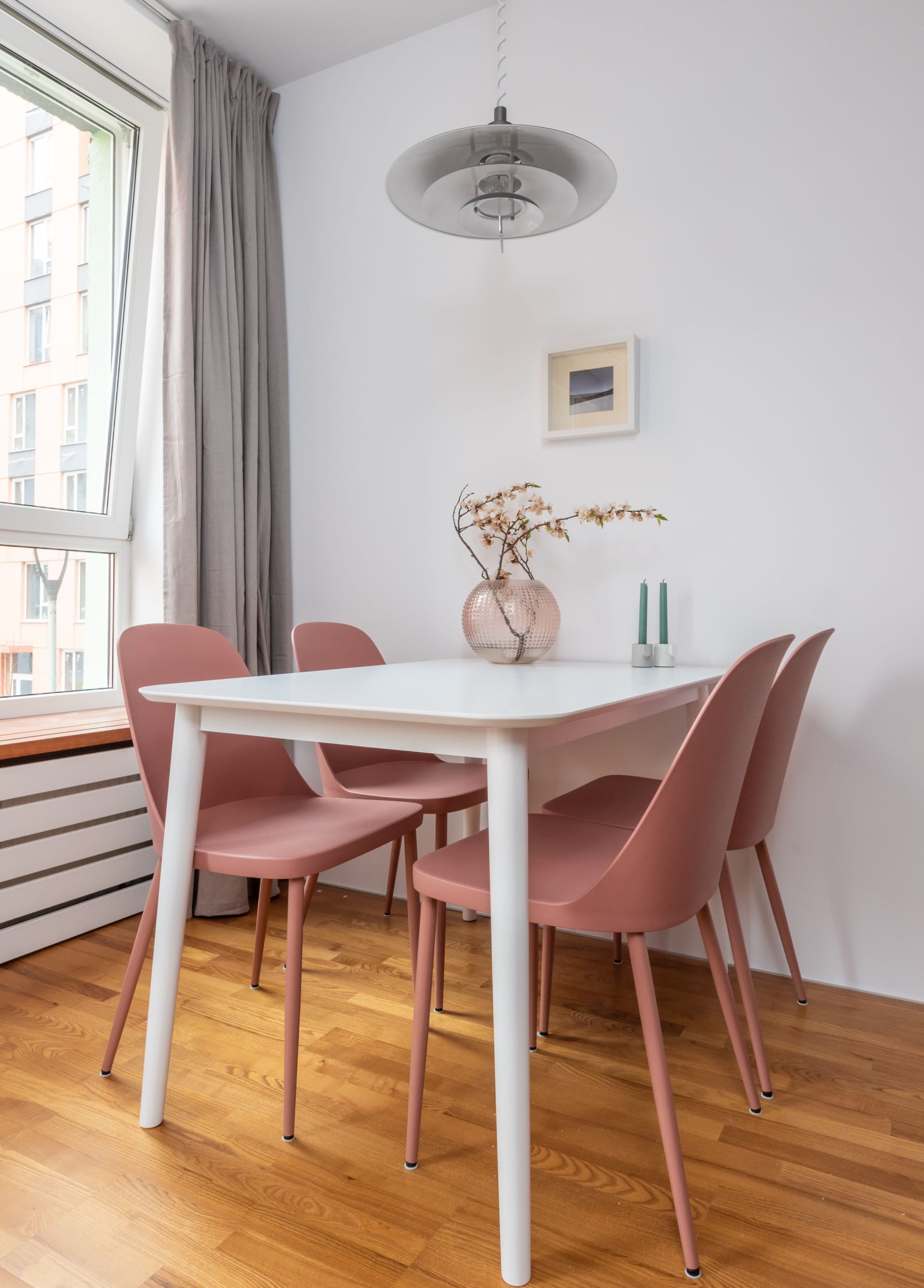 Modern interior of dining room with chairs and table decorated with tender branches of sakura