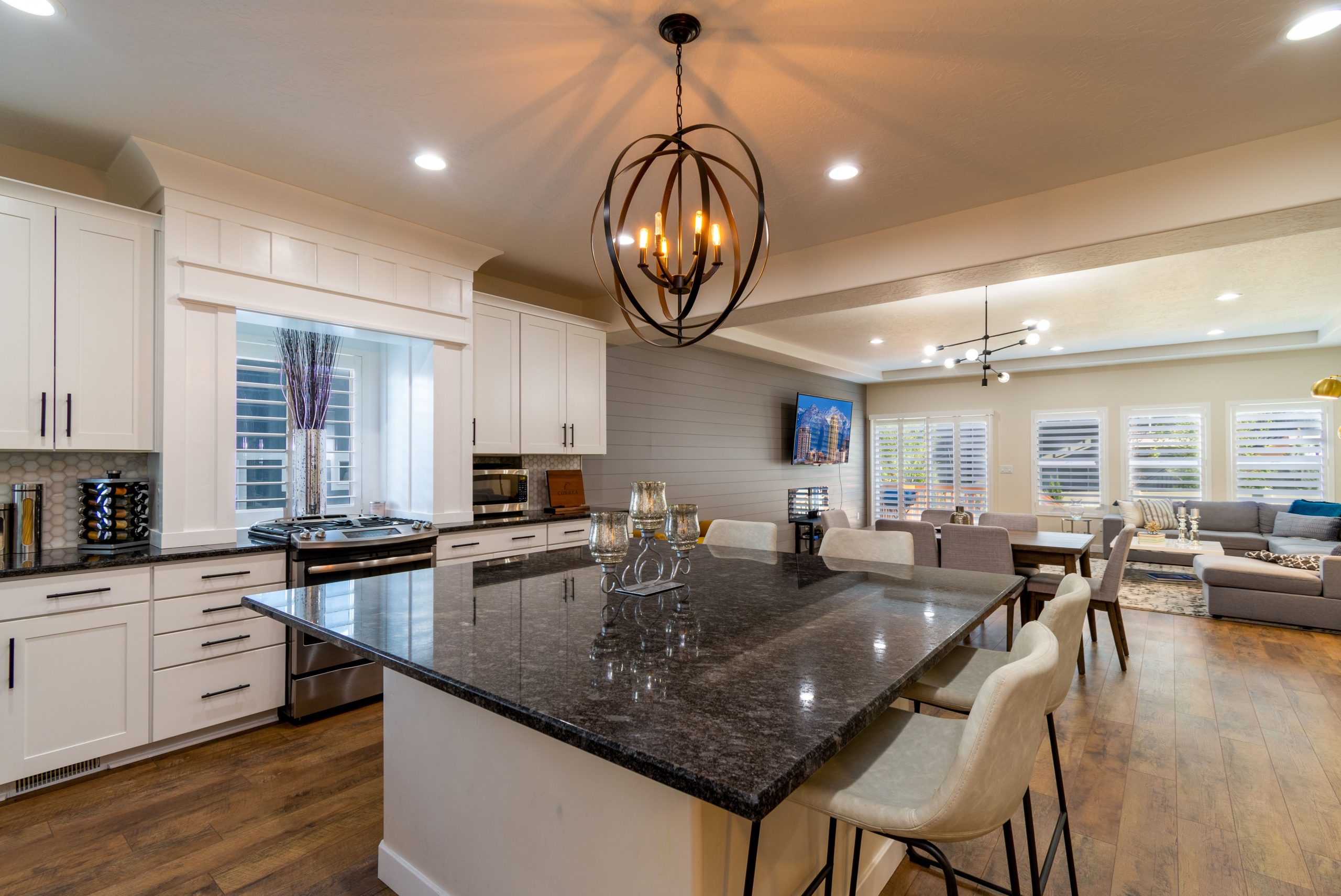 Modern open-concept kitchen and living room with stylish decor and lighting.