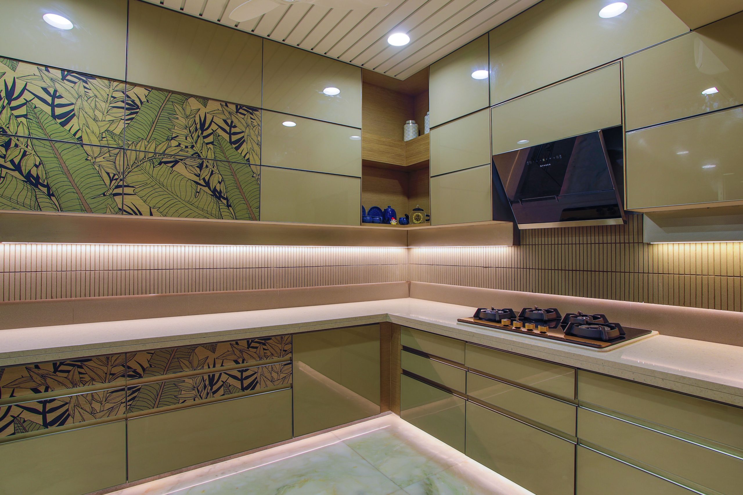 Sleek kitchen design featuring green cabinets, hob, and floral accents.