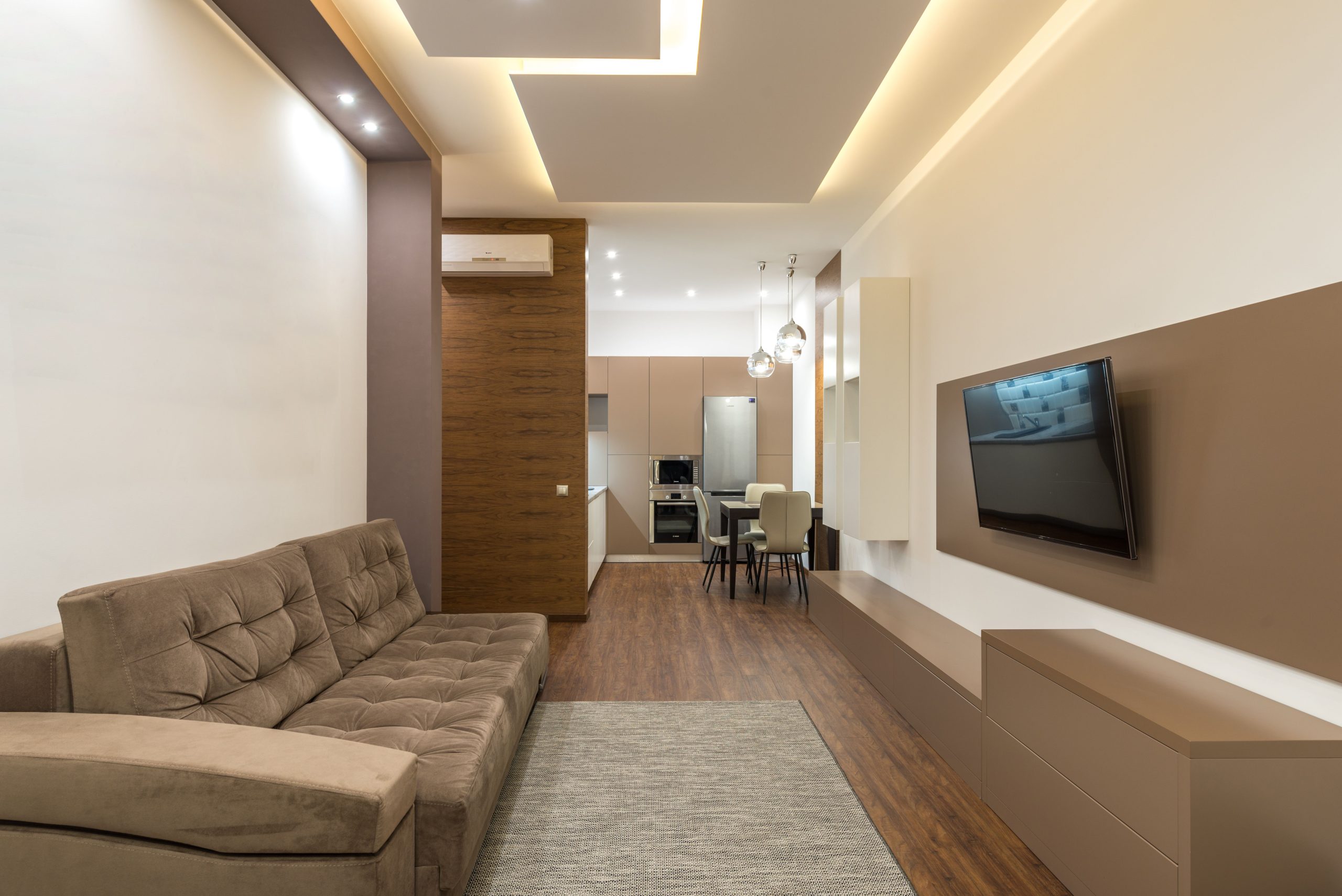 Spacious modern living room featuring cozy furniture, wooden flooring, and minimalist decor.