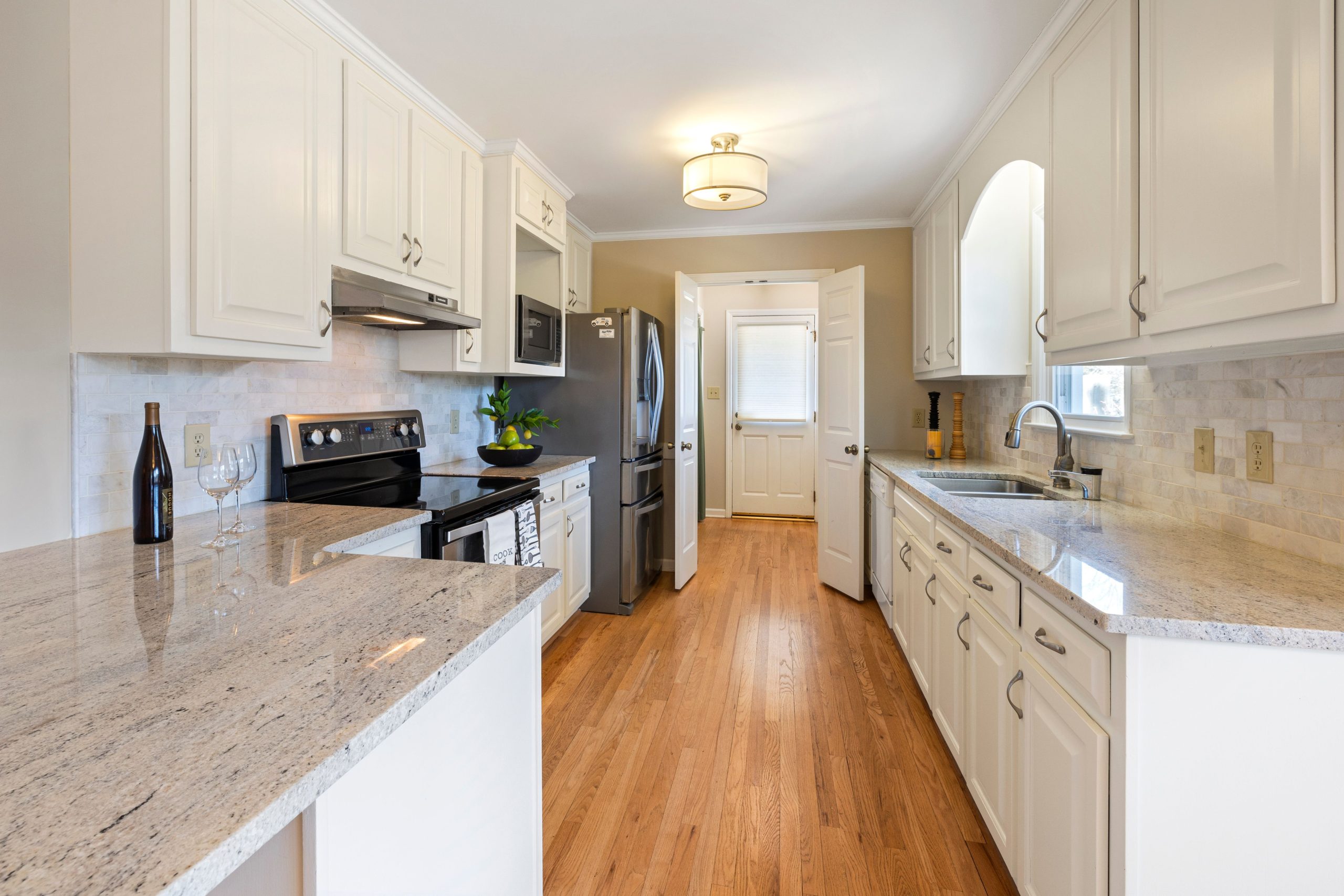 Spacious white kitchen featuring elegant countertops and modern appliances.