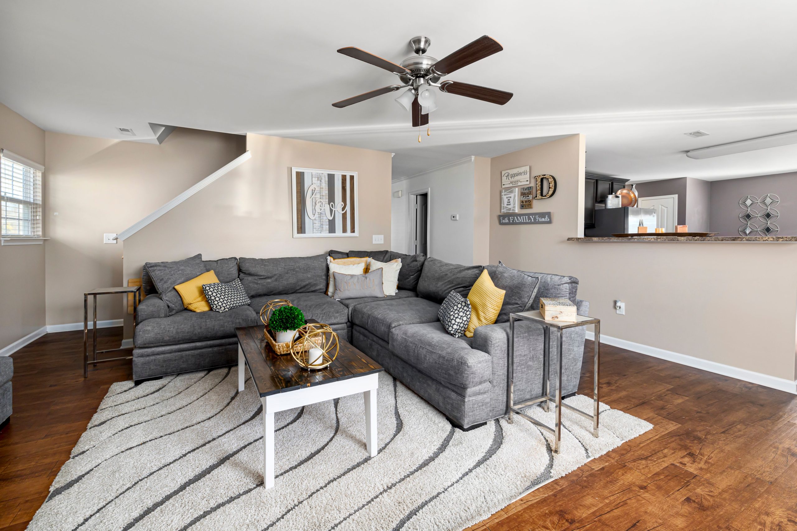Stylish living room featuring a gray sectional sofa, wooden flooring, and decor accents.