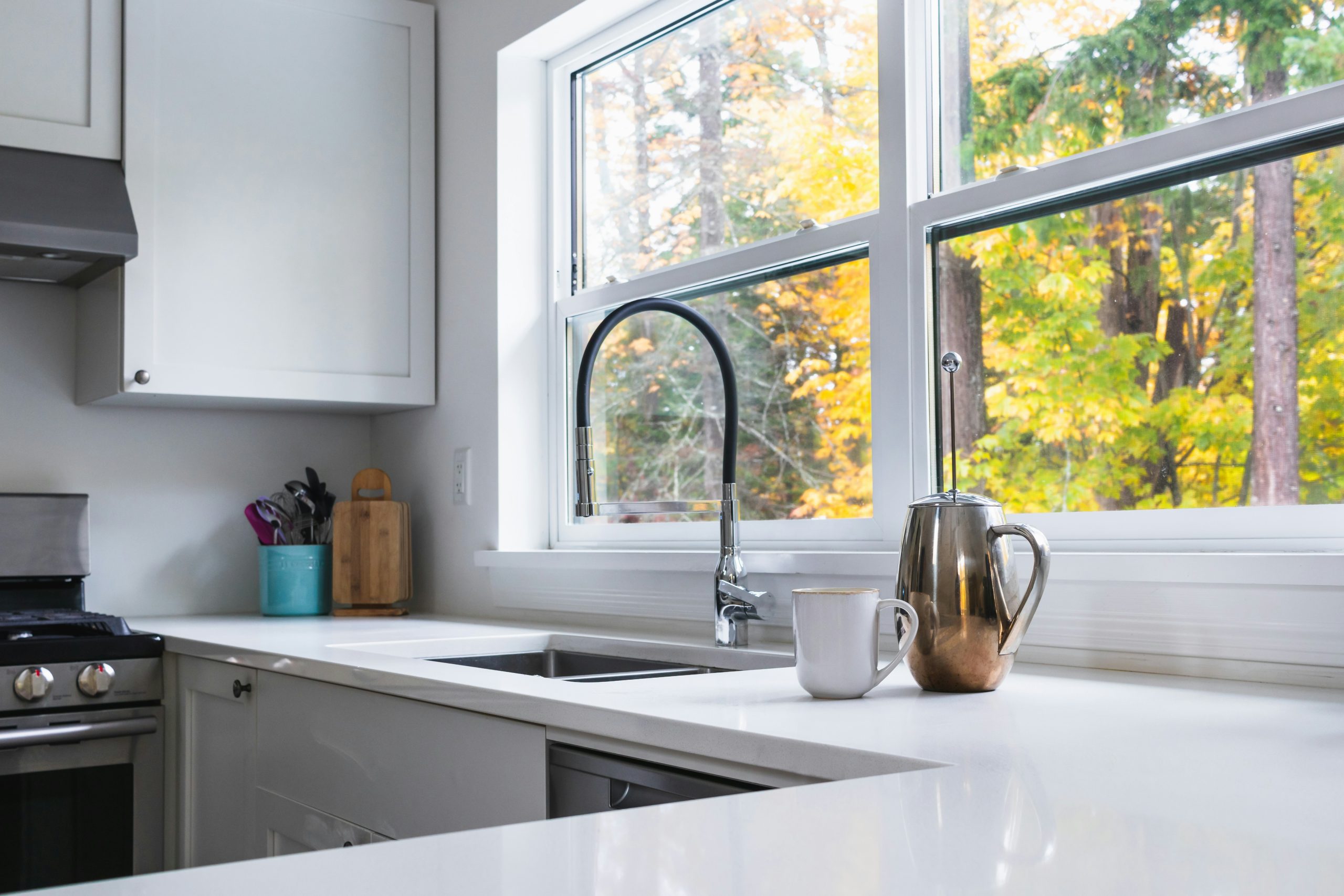 clean white kitchen with coffee cup and frenchpress on counter