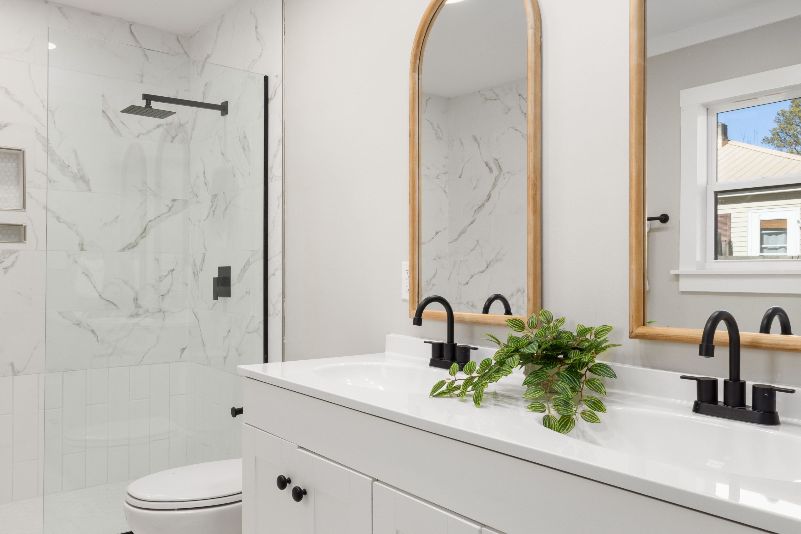 Elegant bathroom design with marble shower and dual-sink vanity.