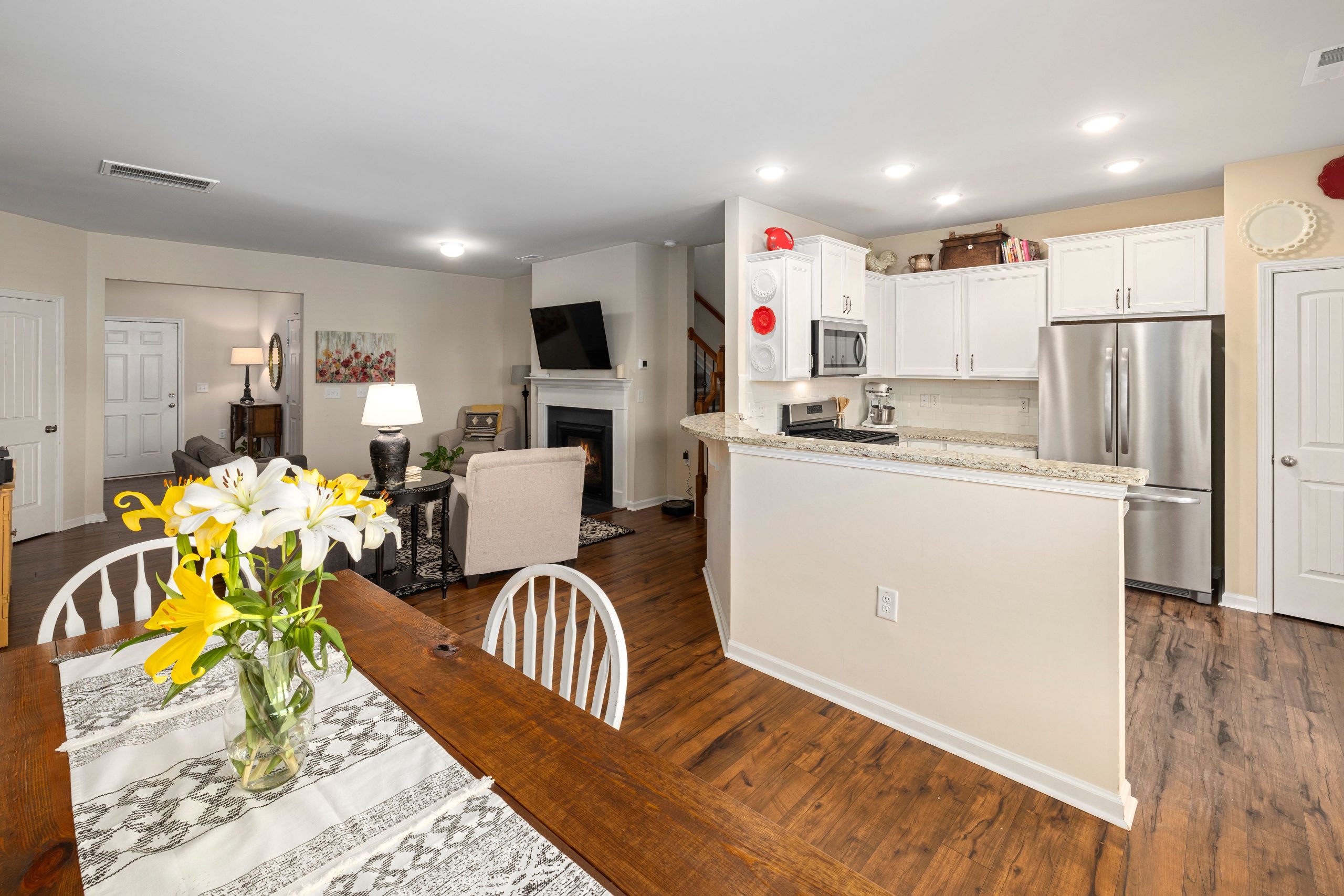 Spacious modern home interior featuring an open-concept kitchen, dining, and living area with elegant wooden flooring.